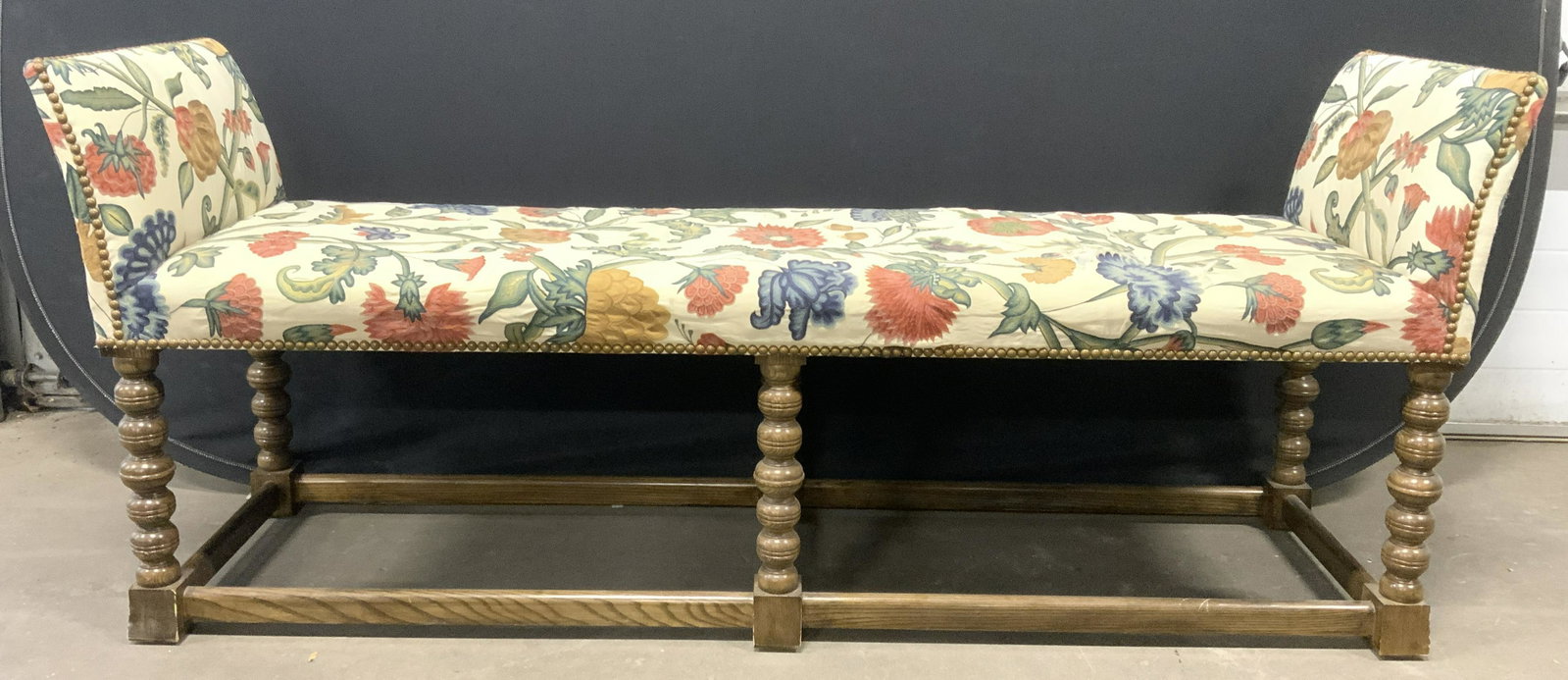 Vntg Russian Embroidery Bench W Nailhead Detail: Bench is vintage. Piece has multi toned floral vine and leaf detailed embroidered upholstery. Bench has gold toned nailhead detail. Bench has brown toned carved wooden base with stretchers in between 