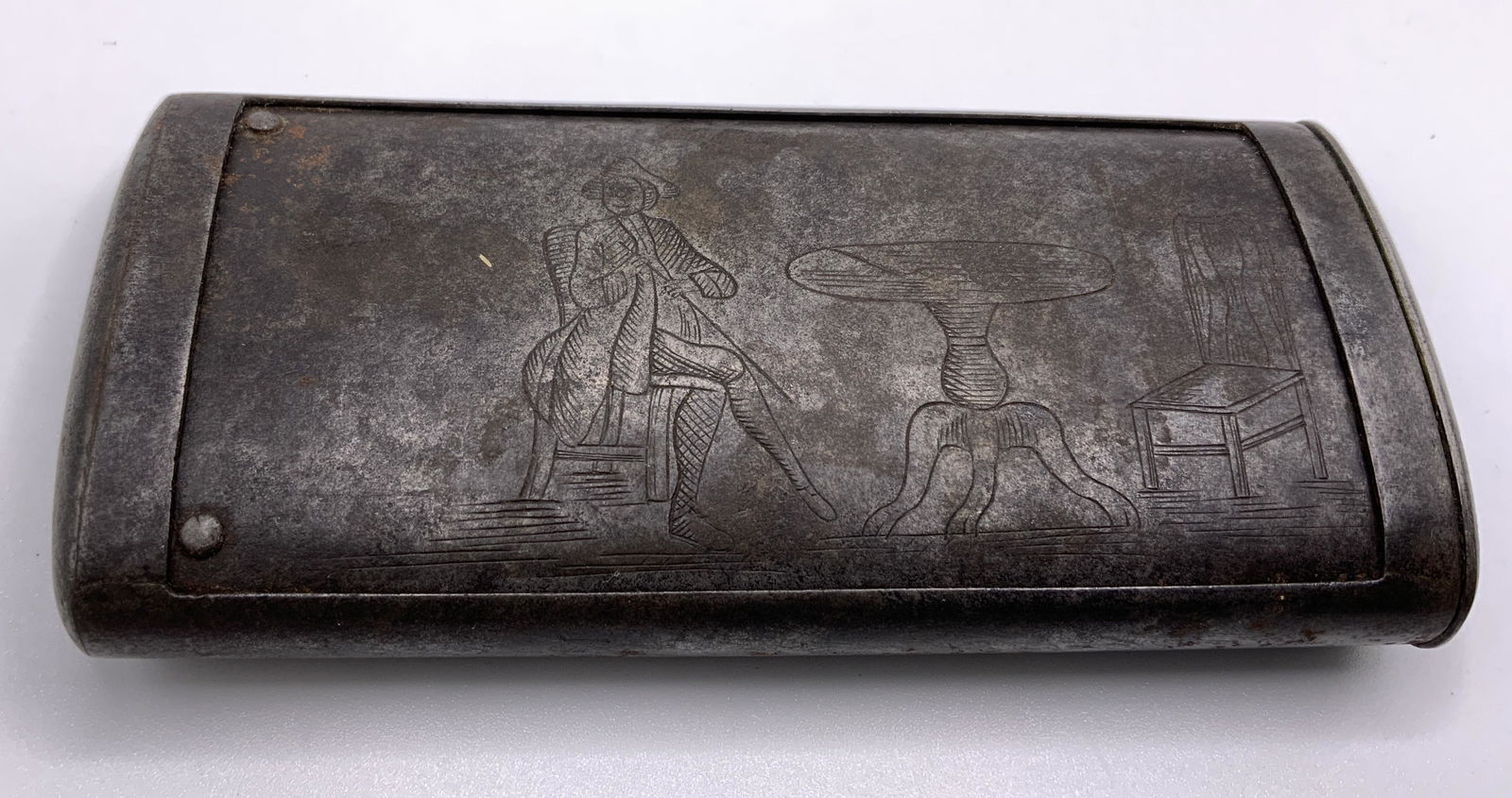 Antique Pierce Metal Vessel: Pierced metal vessel. Decorated with etchings depicting a man sitting at a dining table. Underside is pierced, slides to open. Wear is consistent with age and use. Measures approx 4.25 inches long, an