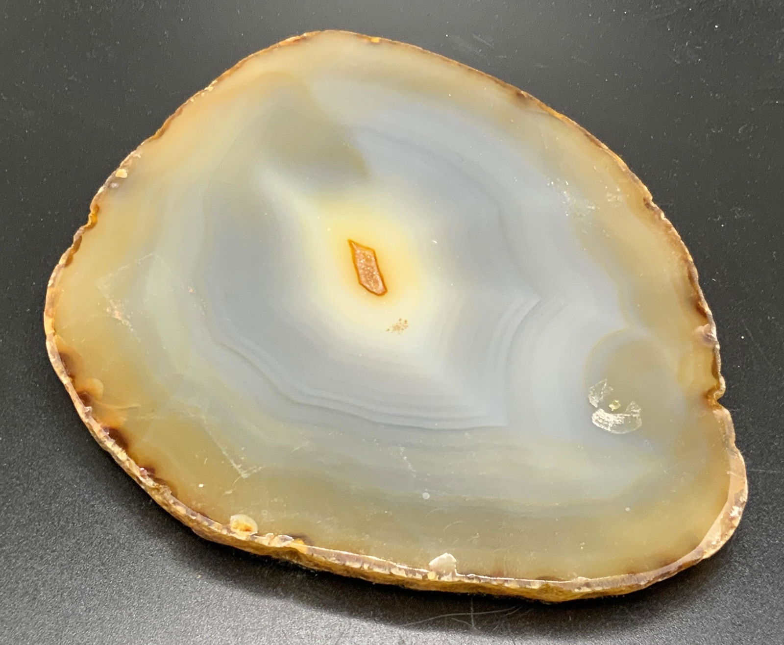 KREISLER Polished Banded Geode Specimen: A polished geode specimen / coaster. Reverse features black felt material and plaque that reads KREISLER One of A Kind Originals. Some surface wear, some residue. Measures approx. 4.5L x 5.5W in. Prop