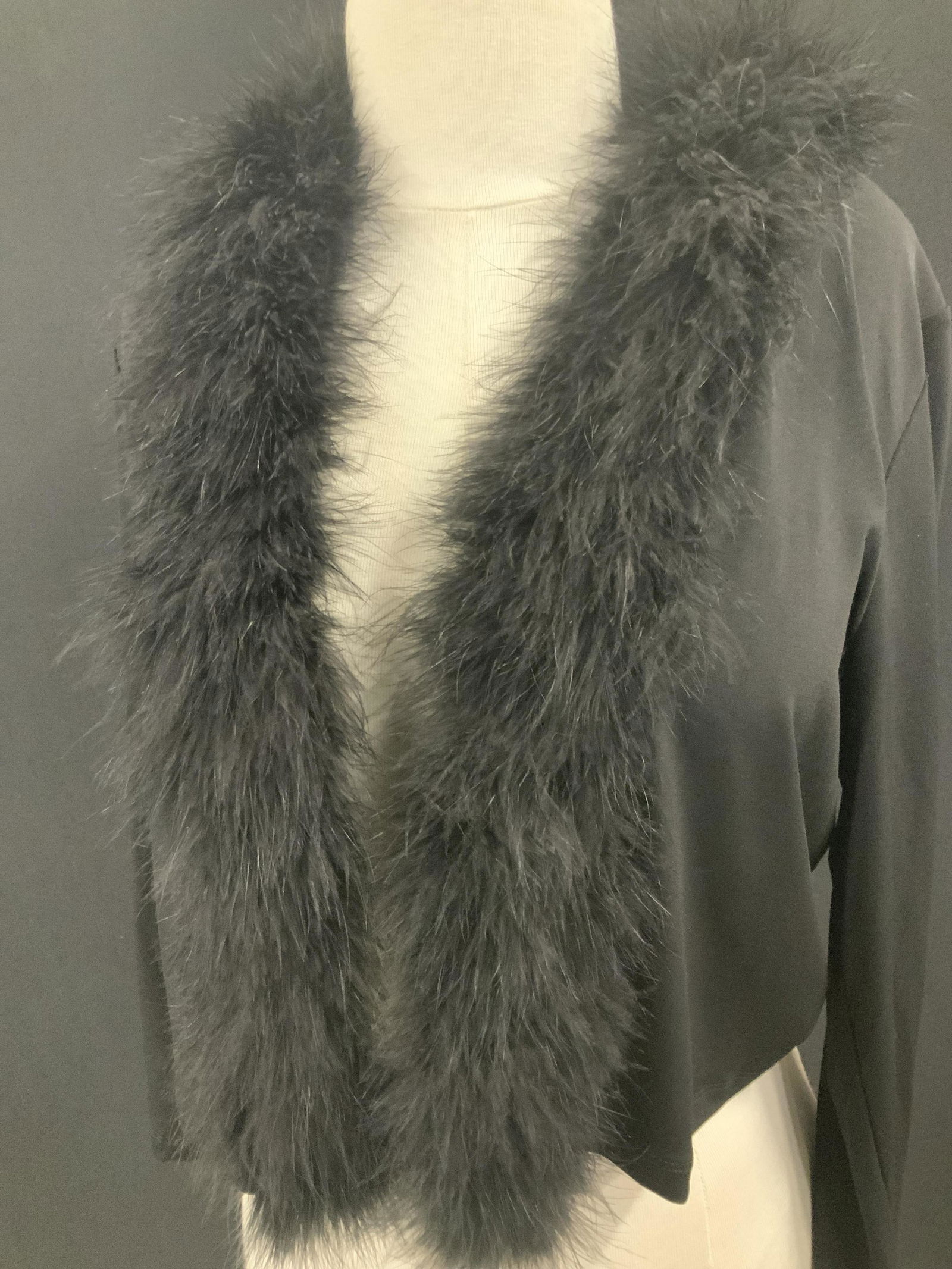 CALVIN KLEIN Dressy Crop Cardigan w/ Feathers: Labeled with designer Calvin Klein, shawl collar and neck has black ostrich feathers on black polyester & elastic garment. Ladies Sz Large. Long sleeves, Length 15.5 in. Dressy for evening wear or spe
