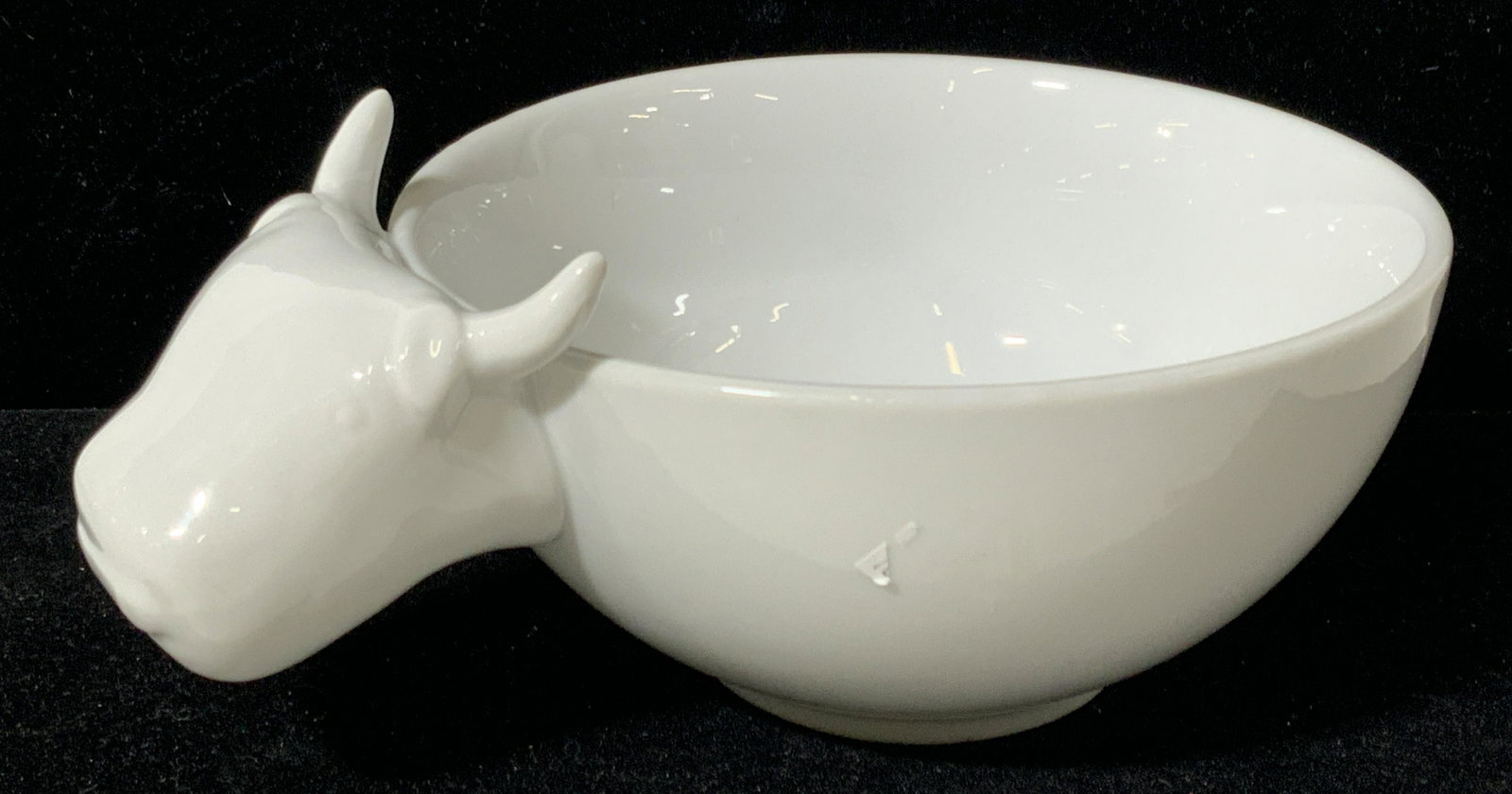 CRATE & BARREL Porcelain Bull Bowl: A white porcelain bowl with a had of a bull with the label â€˜Crate & Barrelâ€™ on underside. Approximately 8.5 in wide and 3 in tall. Some sticker residue on exterior and underside. Crate & 