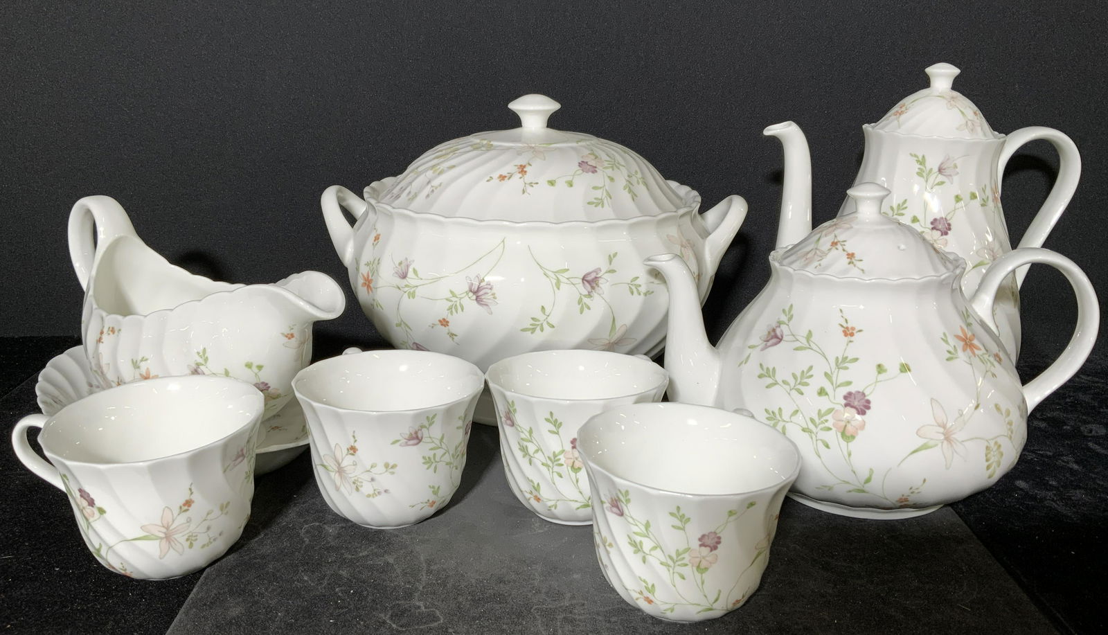 Group Lot 12 Pc Wedgwood Server Accessories: 12 pc Wedgwood server accessories. 2 kettles w lids, 1 tureen w lid, 1 gravy boat w saucer, and 4 tea cups. Decorated with floral printings. Undersides read as Wedgwood Bone China Made in England, Cam