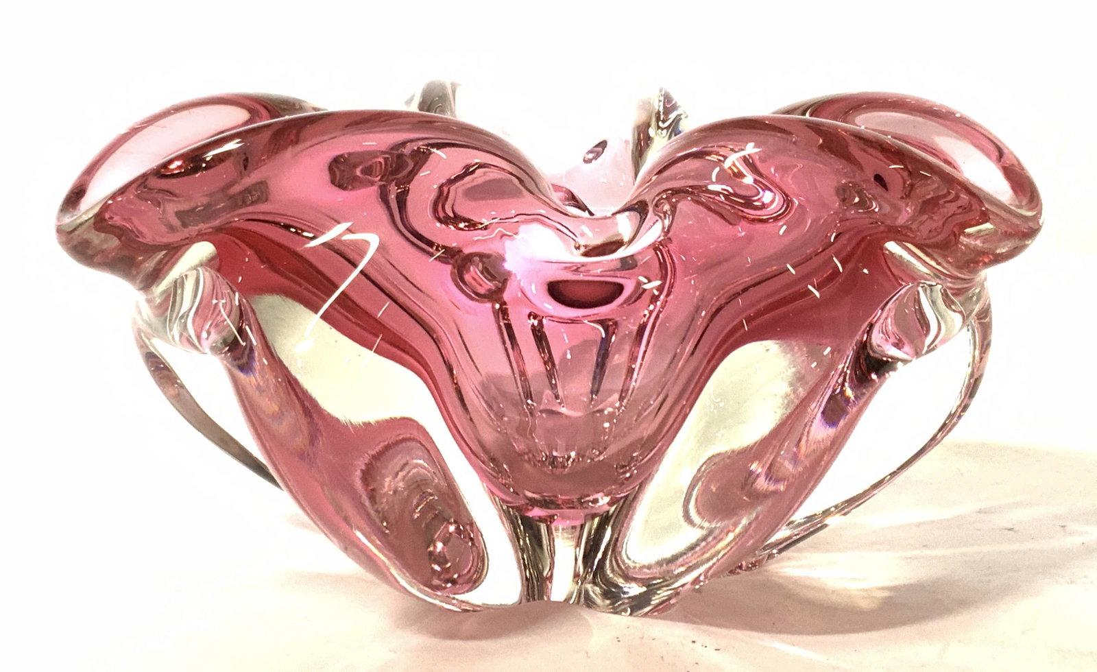 Thick Glass Cranberry Toned Vessel: A vessel made of thick cranberry toned glass, vessel has a floral like shape with a mix of clear glass. Approximately 4.5 in tall. Good condition. Cranberry glass, vintage cranberry glass, glass, deco