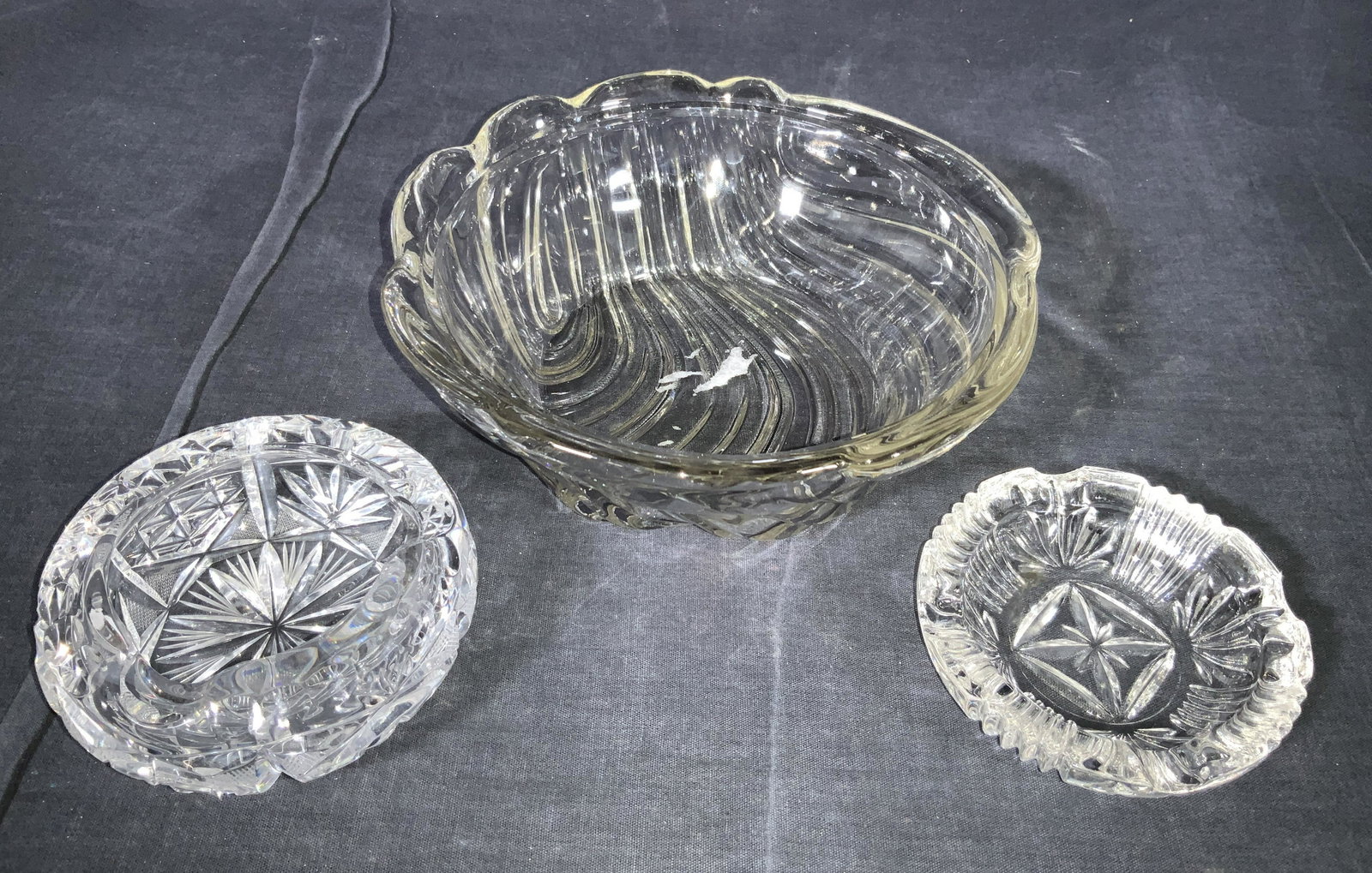 Vintage Glass Bowl & Crystal Ashtrays: A group lot consisting of 1 thick vintage glass bowl with a swirl pattern on exterior, 1 shallow cut glass ashtray with vertical grooves cut into exterior and 1 thick cut crystal deep ashtray with int