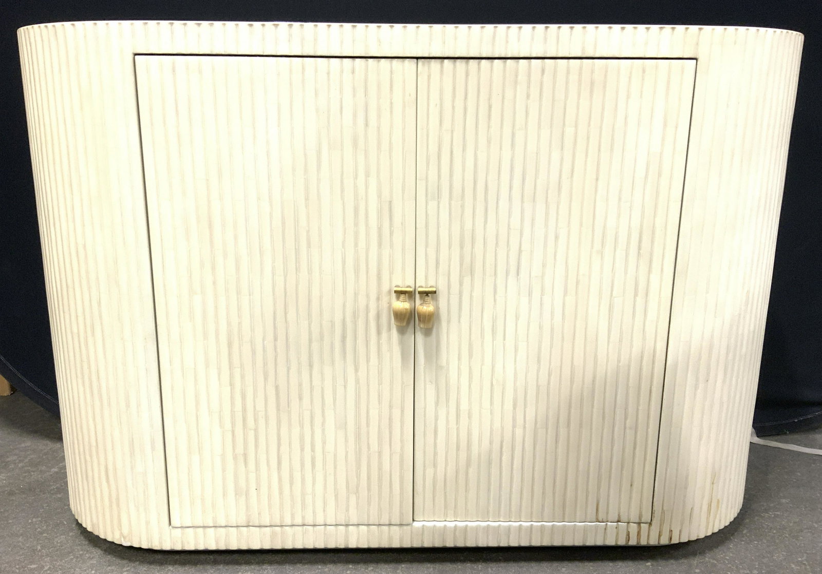 Trademarked Oval Cabinet Console Table: Backside of cabinet has illegible tag. Cabinet appears to possibly have bone exterior with cream toned overlay. Piece measures approx 49 inches long 33 inches tall 18 inches deep. Purchased through NY