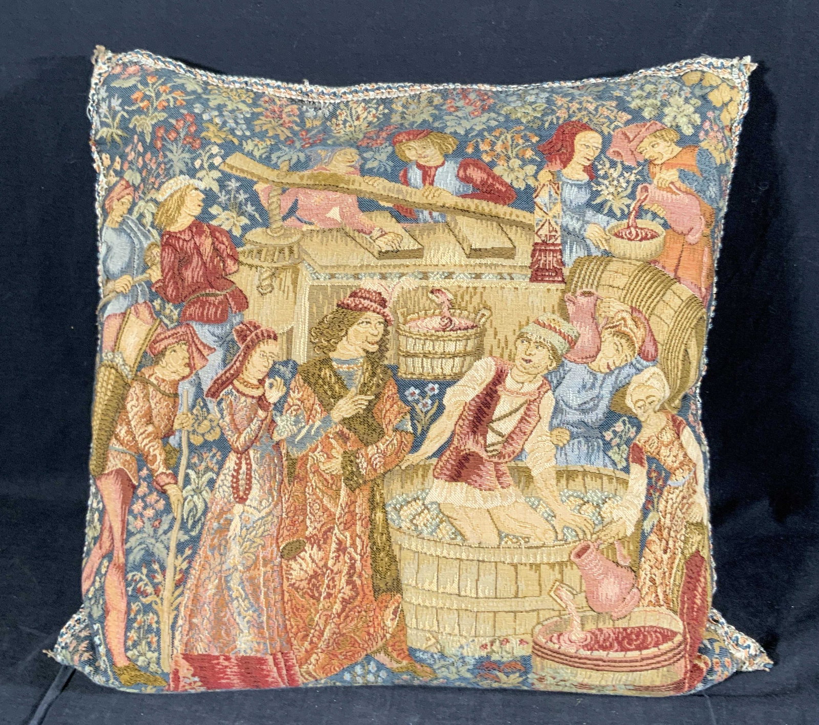 Vintage Tapestry Style Medieval Motif Toss Pillow: A vintage tapestry style toss / throw pillow decorated with a medieval motif on both sides. Scenes feature men and women, some are making wine, stomping grapes, and more. Floral accents on obverse and