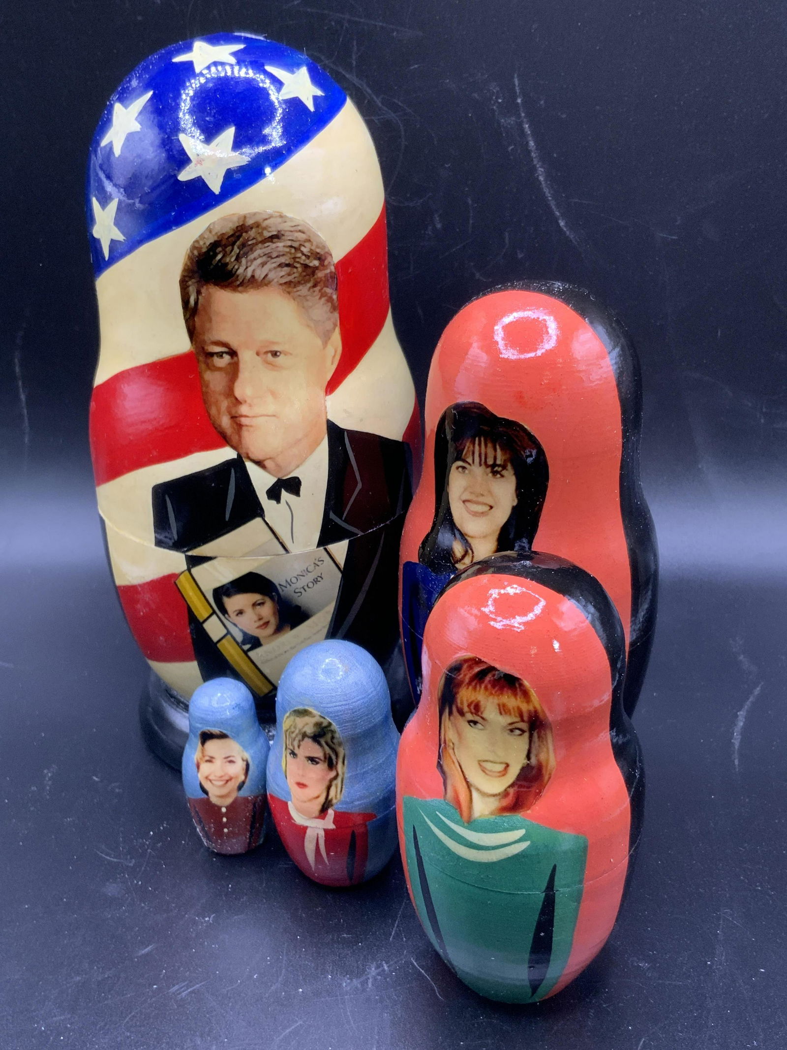 BILL CLINTON & Monica Lewinsky Nesting Doll: A Bill Clinton & Monica Lewinsky nesting doll / matryoshka. Crafted from wood and decorated to resemble former president Bill Clinton, Monica Lewinsky, Hilary Clinton, and other women. Largest piece m