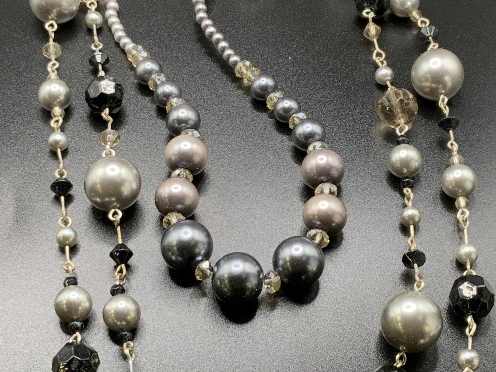 2 Vntg Metallic Beaded Necklaces, LAILA ROWE &More: Two vintage necklaces adorned with spherical metallic hued beads. Faceted crystals throughout. One necklace possesses a lobster claw clasp closure, signed LAILA ROWE. Longer necklace measures approx. 