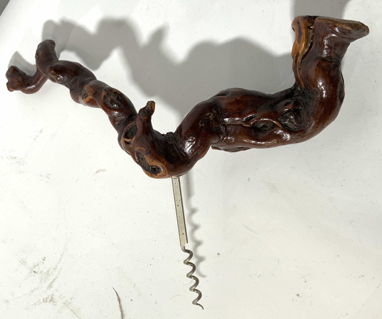 Bonsai Style Wooden Cork Screw: A hand made wine bottle opener made with a polished and stained piece of natural bonsai style wood with a metal cork screw attached through the wood. Wood piece is approximately 13 in long. Wood has n