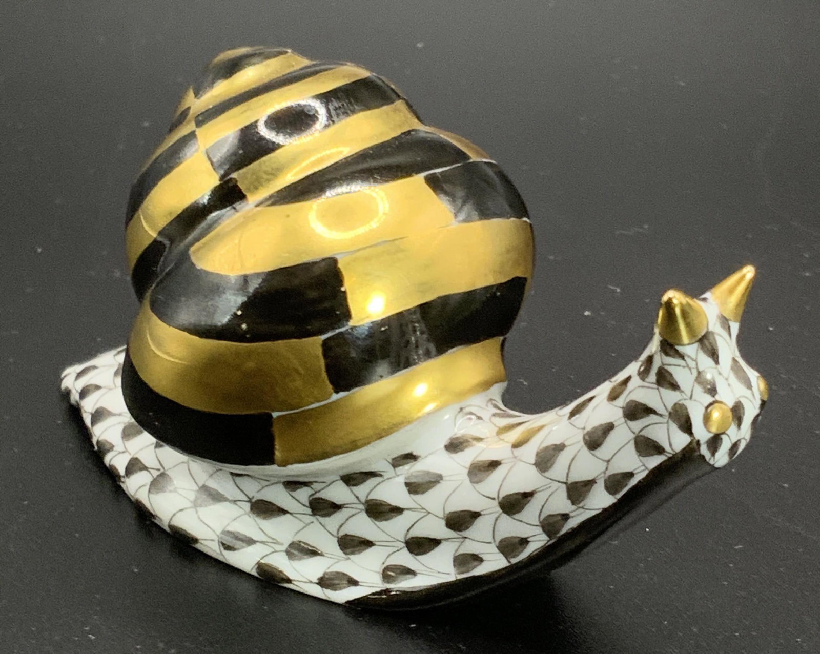 HEREND HUNGARY Hand Paint Porcelain Snail Figural: A hand painted Herend figural depicting a snail. One is standing, one is crouched. Hand painted black and gilt over white. Underside signed HEREND HUNGARY HAND PAINTED. Impressed on underside HEREND, 