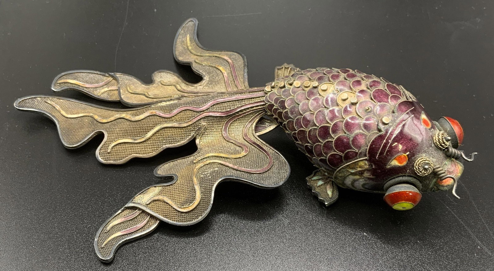 Vintage Articulated Cloisonne Gold Fish: Vintage cloisonne gold fish. Scales, tail fin, and eyes are colored with enamel. Fish body is articulated. Wear is consistent with age and use, some loss present along spine. Measures approx 7 inches 