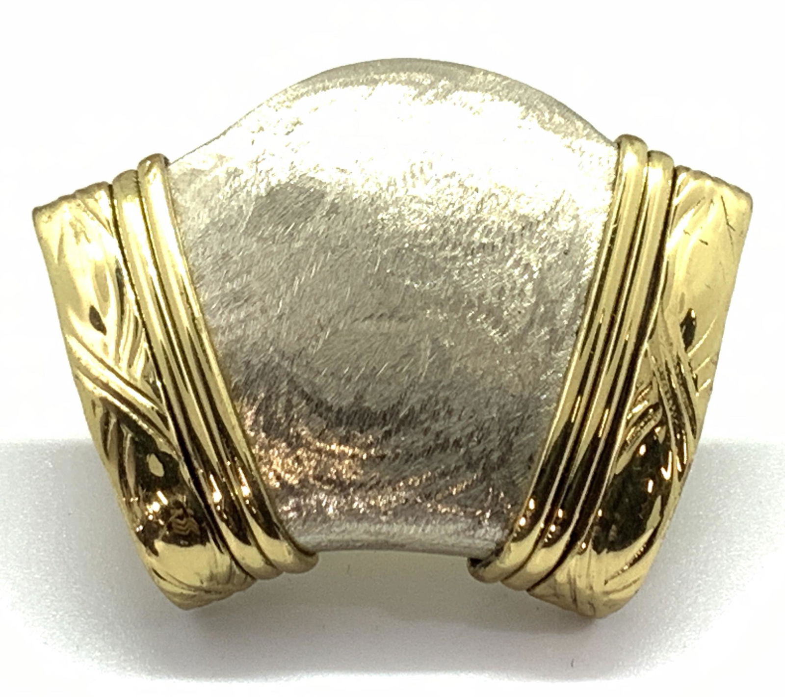 Vintage Gold Toned Scarf Ring: A vintage scarf ring made of gold toned metal interlocking an etched silver toned center piece. Approximately 1.75 in wide and 1.5 in long. Reverse side of ring has welding markings. Estate accessorie