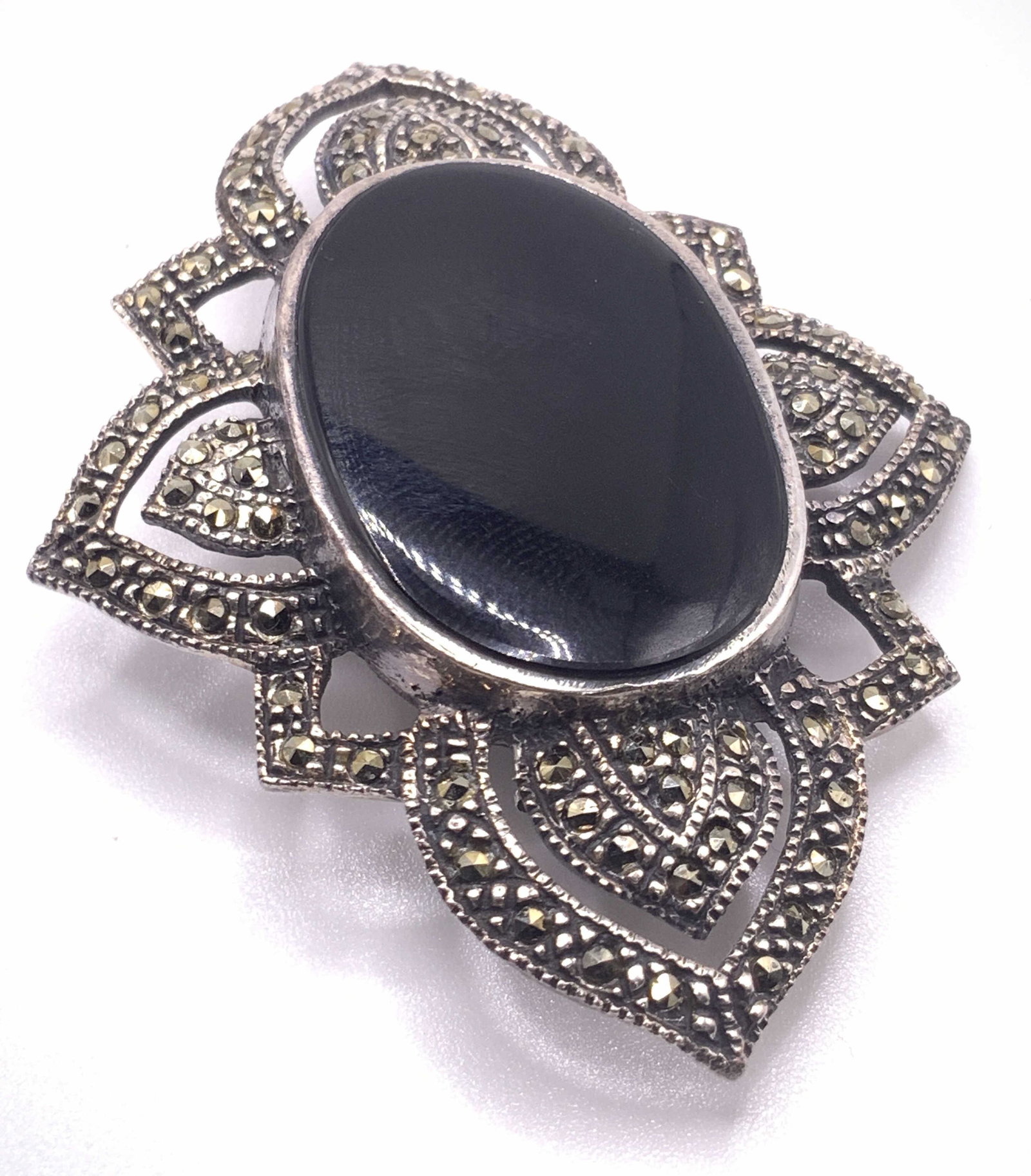 Vintage STERLING SILVER Marcasite Cabochon Brooch: A vintage sterling silver brooch studded with marcasite. Focal point is a polished black glass cabochon. Open metalwork designs. Measures approx. 2.5L x 1.5W in. Total weight .42 ozt. Reverse marked C
