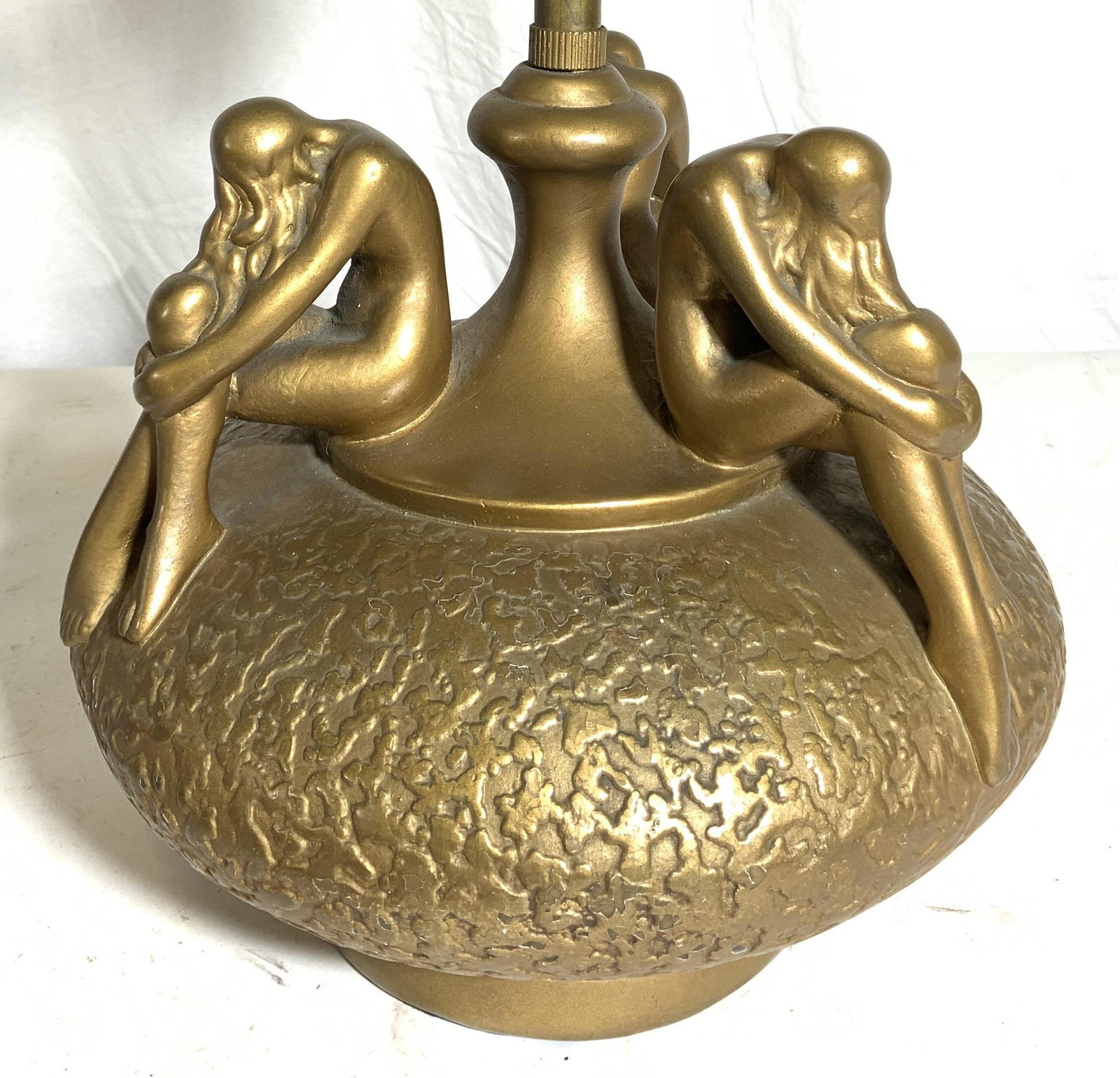 Vntg Gold Leafed Metal Lamp W Female Nudes: Lamp is gold leafed and metal, possibly iron. Piece has 3 seated female nude figures. Lamp base is circular shaped. Lamp has 2 bulb sockets. Piece is vintage possibly antique. Lamp measures approx 19.