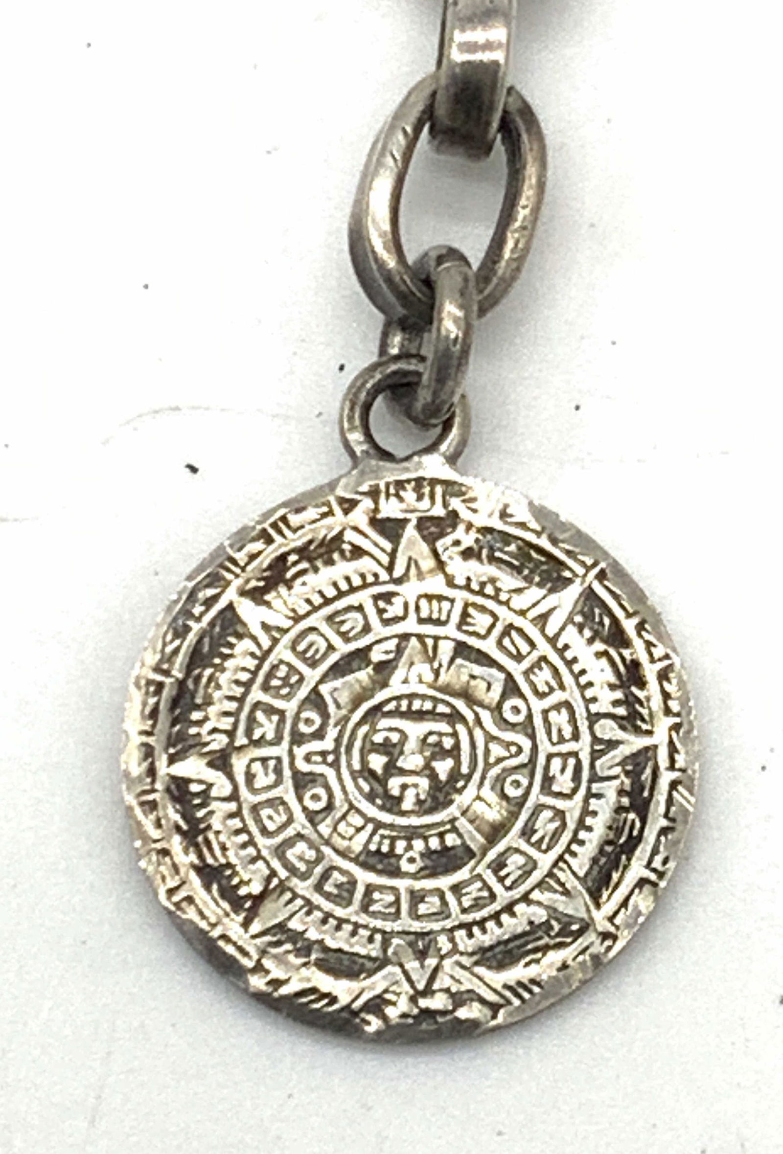 Mexican Sterling Silver Aztec Calendar key chain: A sterling silver Mexican Aztec keychain, marked Mex MD-15 0925 on hook on chain and 925 DM D-24 MEX MD 15 on back of charm, charm on keychain resembles the Aztec calendar. Total weight 0.36 ozt. Appr