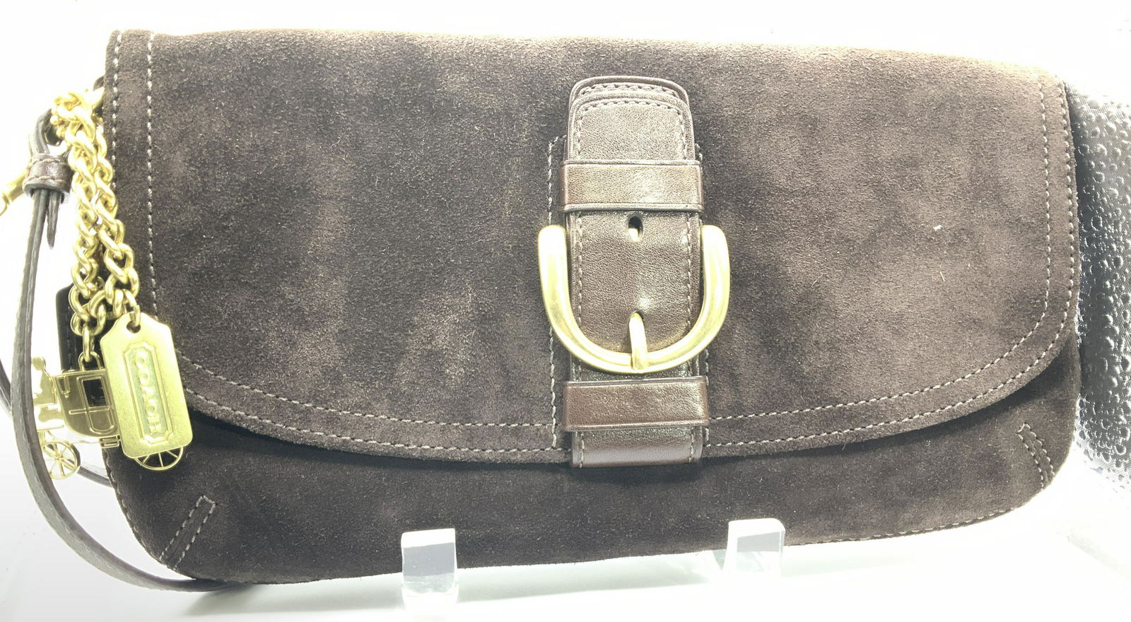 COACH Suede Clutch w Wristlet Strap: Coach chocolate brown suede clutch, fold over flap with gold tone buckle hardware, snap closure. Hand wristlet strap with attached COACH leather tag and brass Coach and Coach horse Charm tags. Blue sa