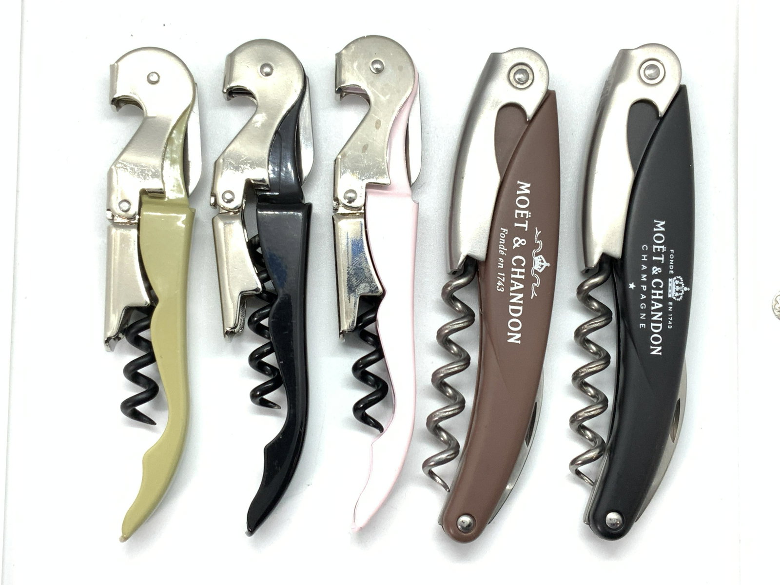 5 Cork Screw Bottle Openers: A group lot of 5 bottle openers cork screws. 2 marked MoÃ«t & Chandon Champagne, 1 black, 1 brown. 1 pink opener with The Beverly Hills Hotel on the side. 1 light olive green marked Eataly on the si