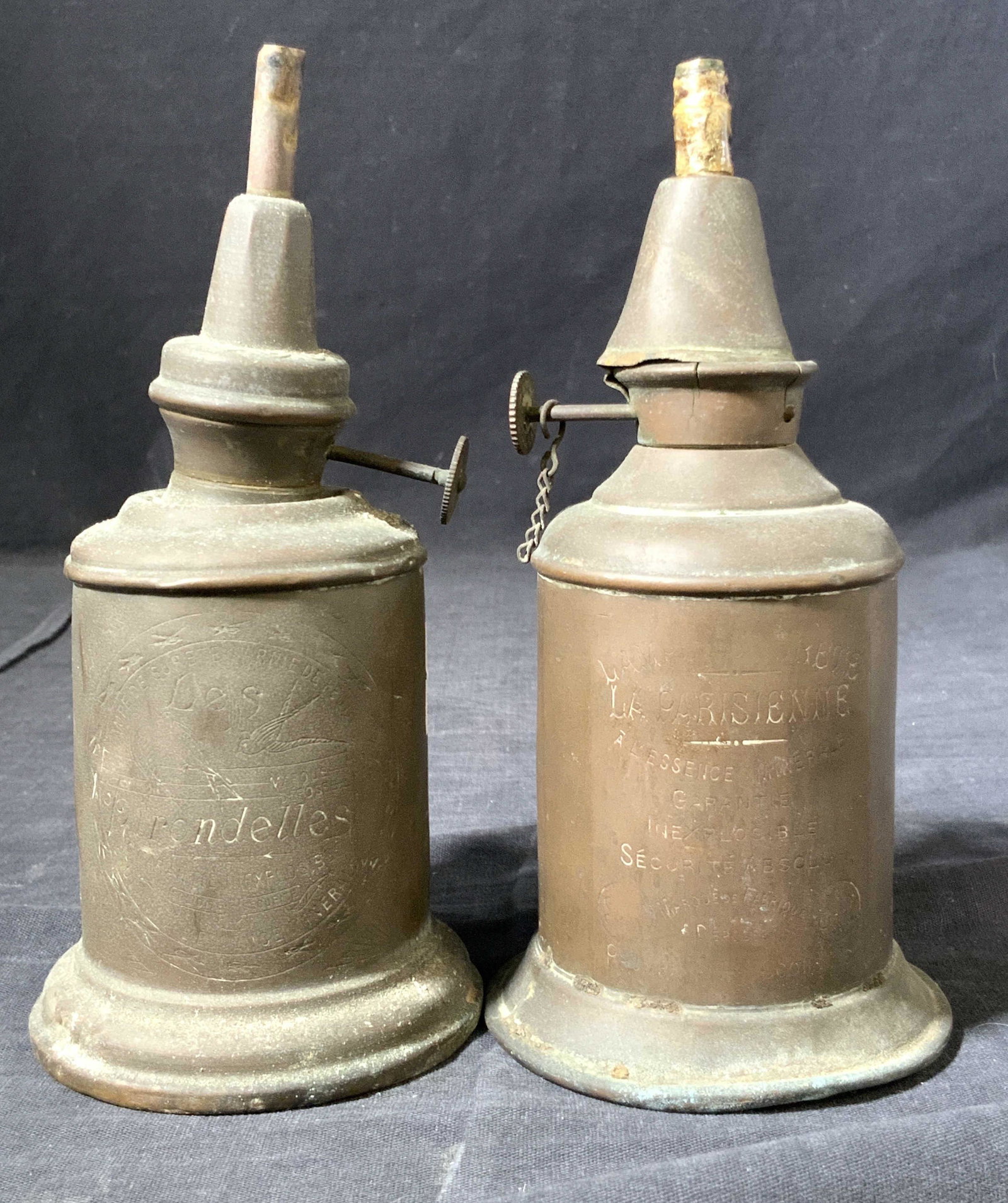 Vintage Iron Oil Lamps: A pair of vintage iron oil lamps, marked on exteriors lampe de surete garniede de feutre. Approximately 7 inches tall. Condition is consistent with vintage age and exposure. Vintage decor, vintage iro