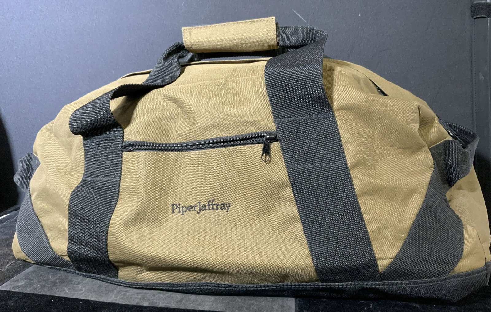 PIPERJAFFRAY Duffle Bag: PIPERJAFFRAY Duffle bag. Olive toned material, reads as PiperJaffray. Measures approx 13 inches h and 24 inches w. Velcro affixed handle, Velcro pockets, zipper pocket. travel bag, carry all, duffel, 