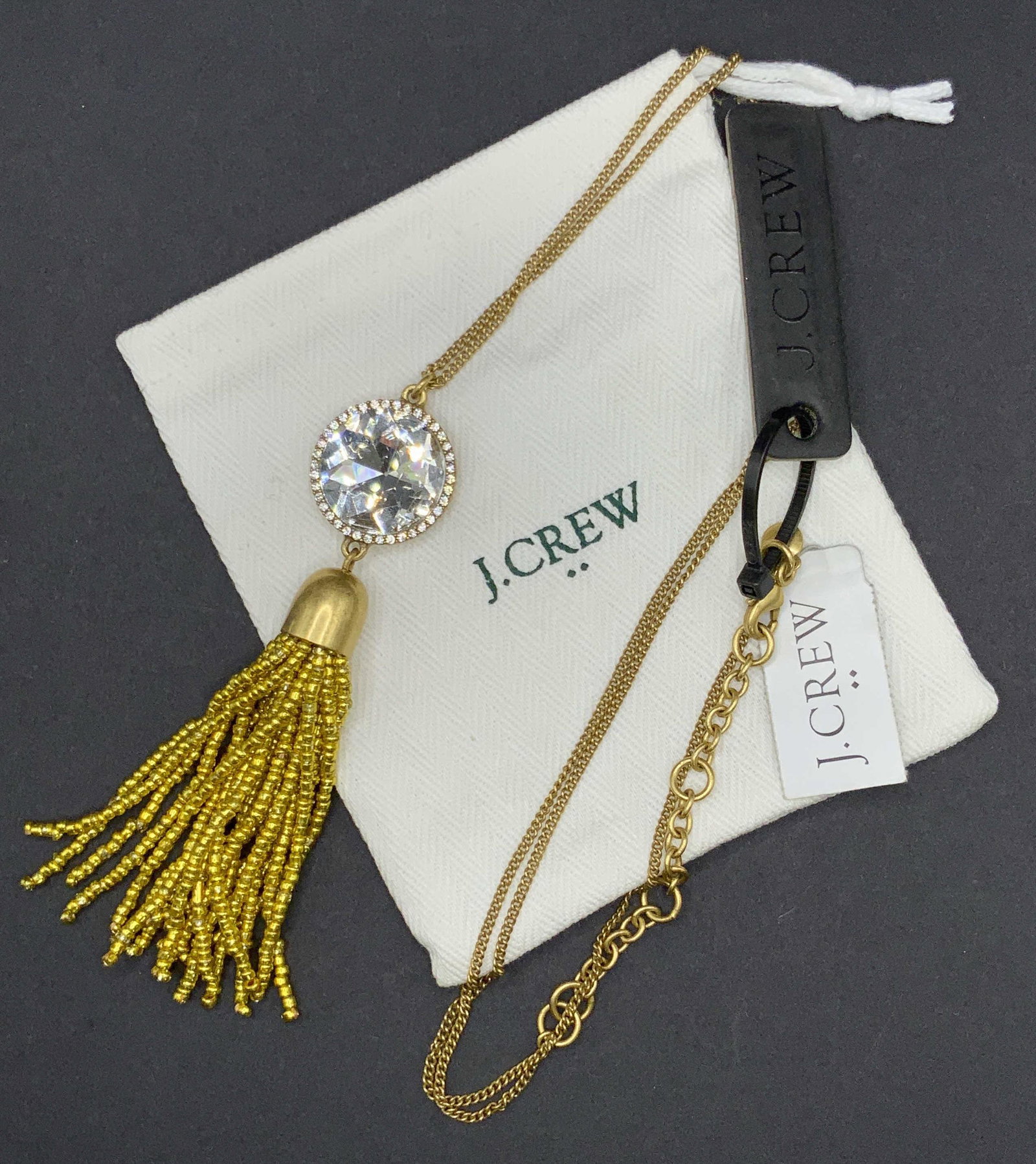 J. CREW Crystal Tassel Pendant Necklace, Jewelry: A gold tone metal chain necklace accented with a faceted crystal pendant. The pendant also features dangling seed bead tassels. Length approx 31 in. Lobster claw clasp closure. Original tags attached,