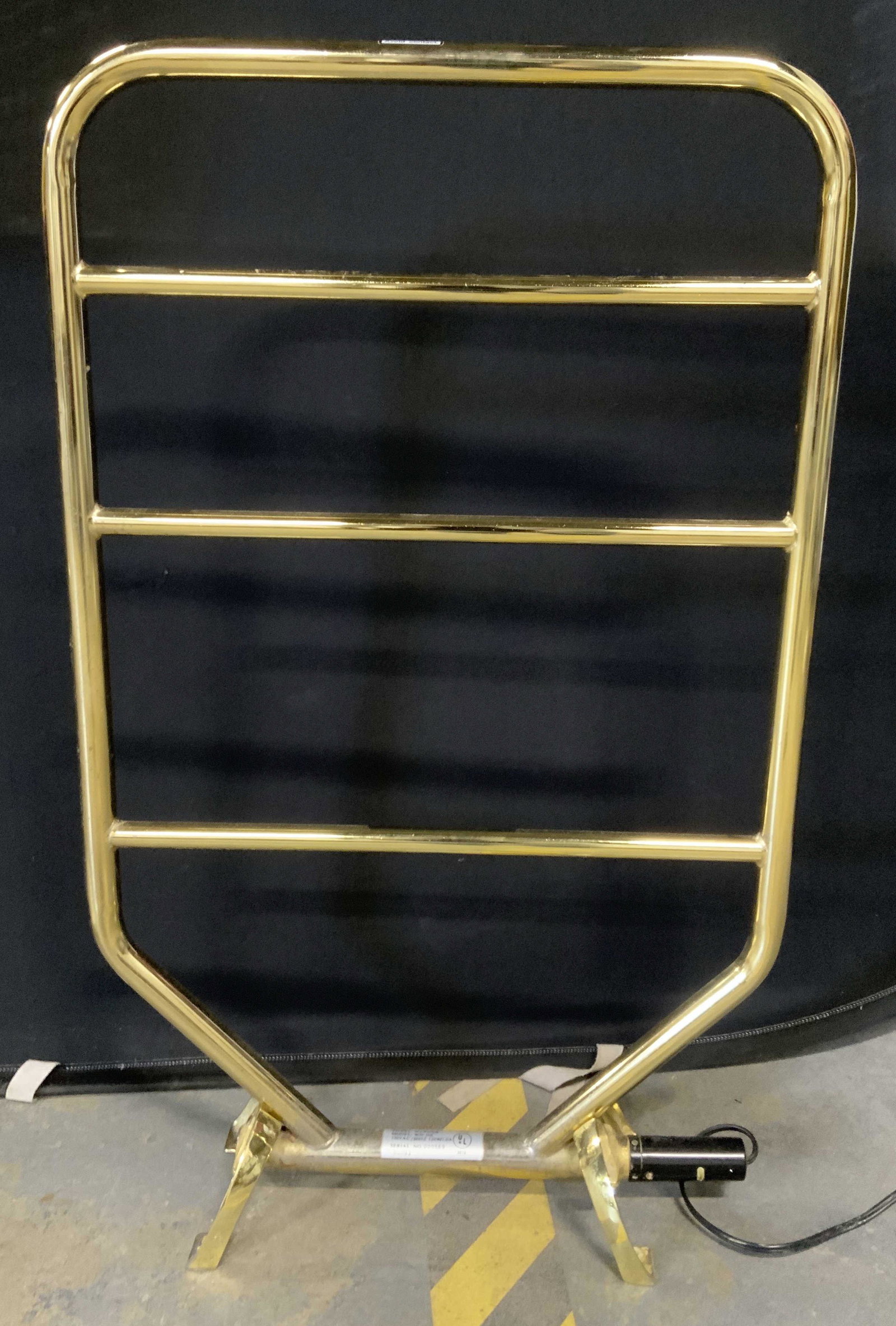 Brass Toned Towel Radiator: Brass towel radiator. Possibly vintage. Functionality has not been tested. Surface wear consistent with use. Measures approx 33.75 inches h and 21.75 inches w. Property of a Manhattan New York estate.