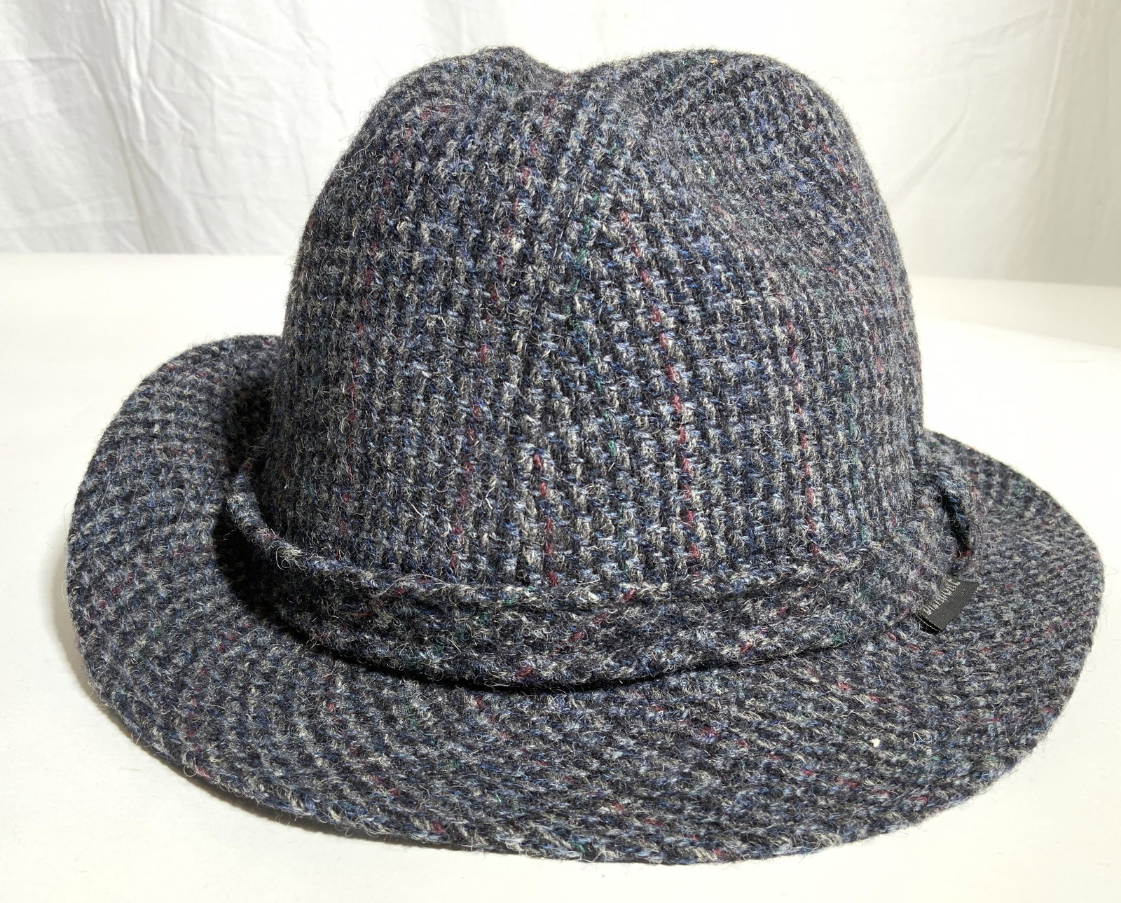 BILTMORE HARRIS TWEED Hand Woven Wool Hat: Embroidery and Tags read BILTMORE HAND WOVEN HARRIS TWEED. Hat is black and charcoal toned. Piece is woven from wool. Hat ribbon matches rest of hat. Piece measures approx 5 inches tall 8.5 inches wid