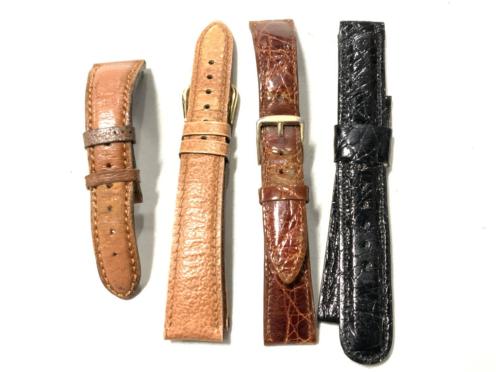 4 Leather Wrist Watch Straps: A group lot of 4 leather wrist straps, 1 light tan leather strap with gold toned clasp, 1 black alligator leather strap marked Baby Alligator. 1 burnt sienna toned leather marked Genuine Crocodile, 6m