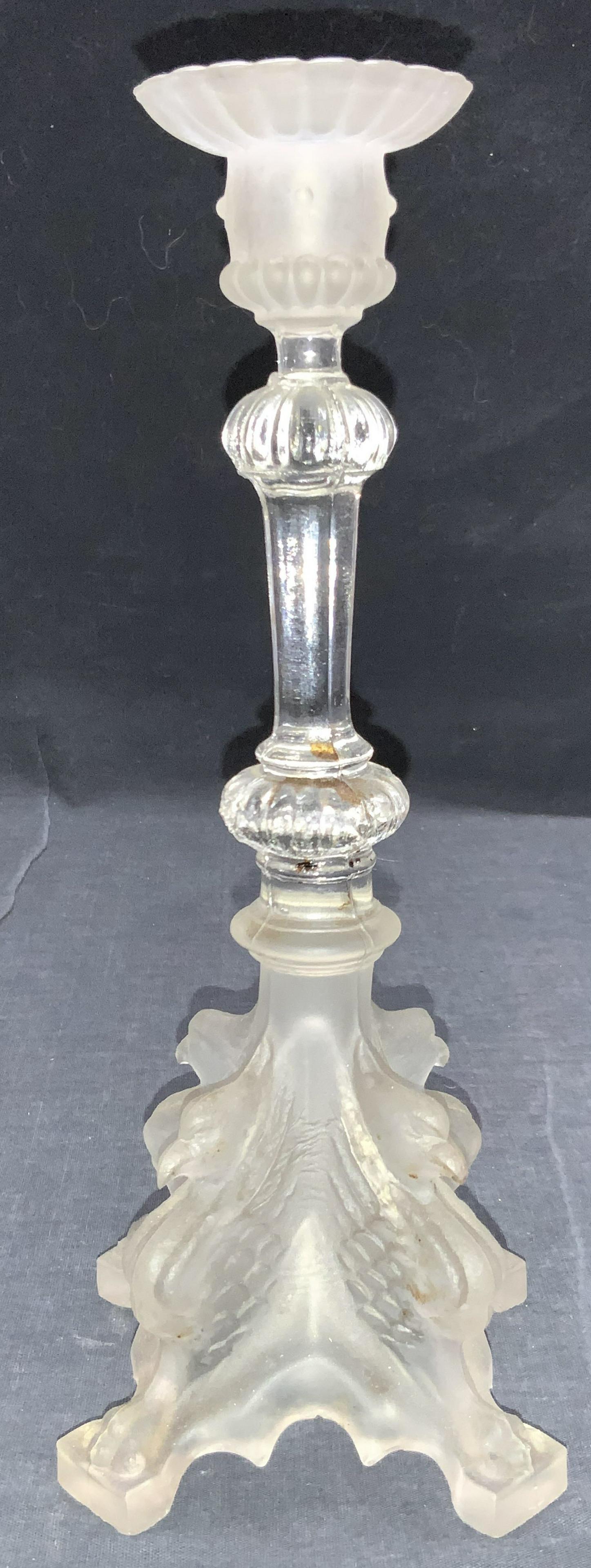 Frosted Glass Bird Motif Candle Holder: A 4 footed candle holder made of glass. Base and rim are frosted glass. Base has motifs of birds, possibly Phoenixes. Stem is clear glass. Approximately 11 inches tall. Some residue throughout. Froste