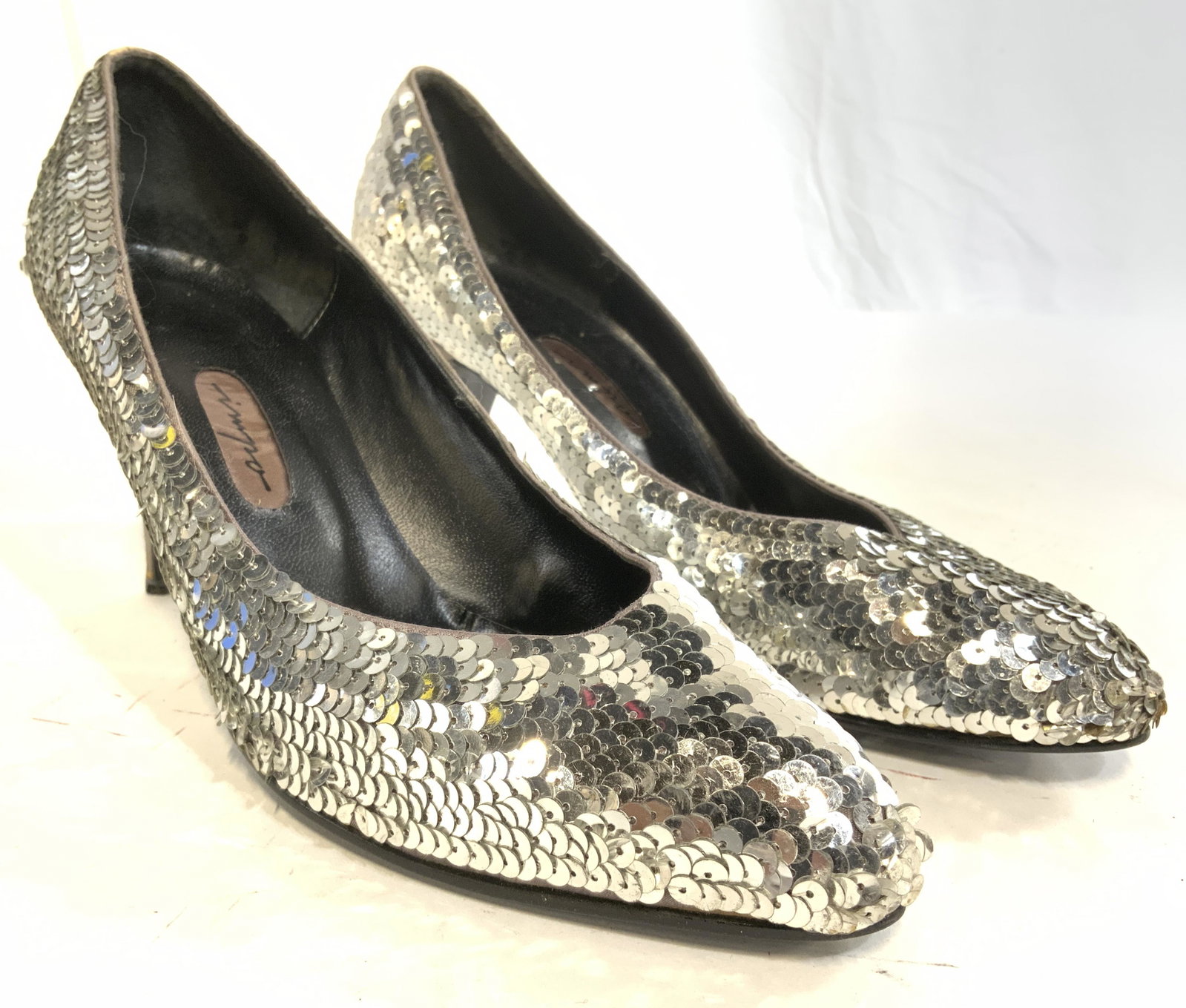 IMPO Sequin Heels: Inner sole of heels read IMPO. Shoe exterior has silver toned sequin detail. Interior is black toned, appears to be leather. Heels are 3 inches high. Shoes measure approx 9.5 inches long5.25 inches ta
