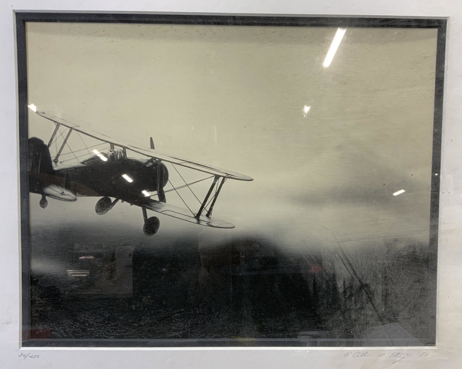 Signed LMT Ed Photograph of Early 20th C. Plane: Signed Photograph of Early 20th C. Plane, signature to lower right illegible, edition number to lower left reads 32/50, shows airplane in sky, measure 20 1/4 x 16 1/4 inches, window measures 13 1/2 x 