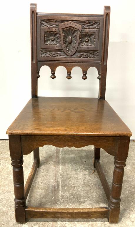 Vintage Carved Wooden Side Chair: A vintage, possibly antique, carved wooden side chair. Rich hued wood, visible wood striations. Ornately carved back features floral and crest motif. Measures approx 35Height x 16Depth x 19Width, inch