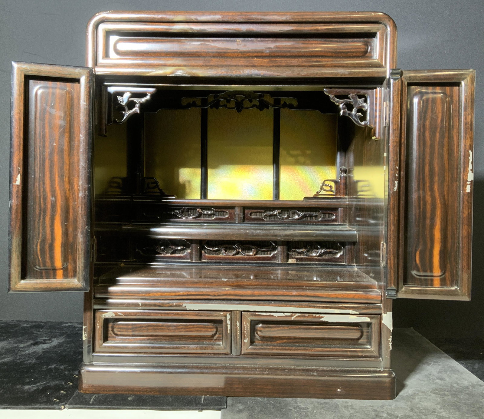 Wooden Buddhist Altar: Wooden Buddhist altar. Folding doors, multi tiered interior, houses 2 drawers and an extending tray. Surface wear present, packing tape residue present. Wood is veneered. Measures approx 19.25 inches 