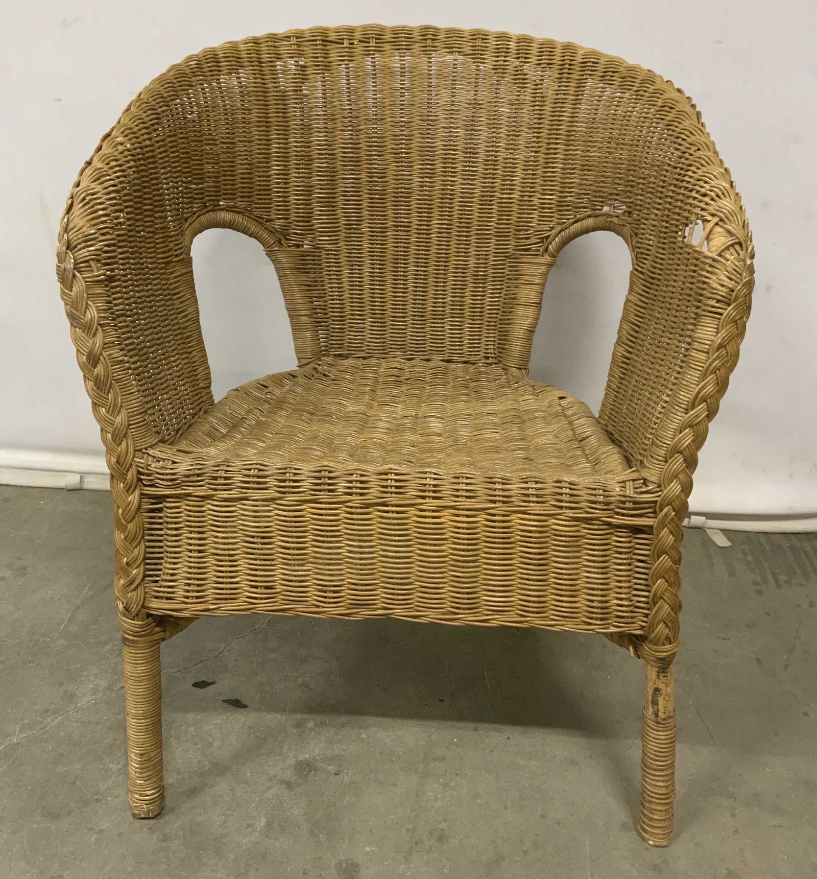Woven Wicker Armchair: Woven armchair, possibly vintage, crafted from woven wicker. Surface wear and scratches present are consistent with age and use, loss to wicker, supporting structure requires repair. Measures approx 3