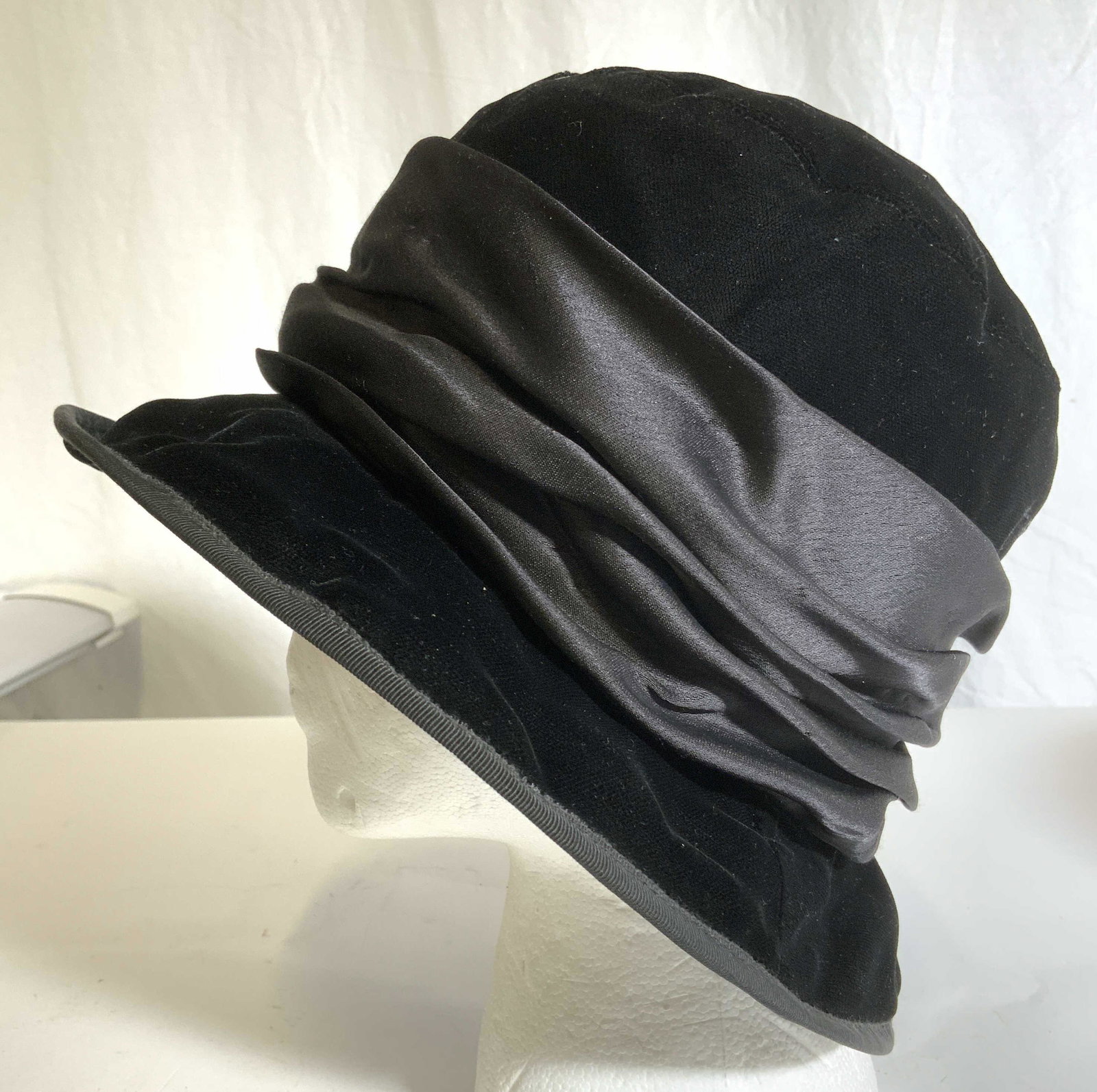 BERGDORF GOODMAN ANDREW WILKE Rayon Hat M: Interior has tags which read BERGDORF GOODMAN ANDREW WILKE MADE IN ENGLAND 100% RAYON. Size is Medium. Piece is black with maroon interior. Measures approx 11 inches wide 6.5 inches tall. Hat, rayon h