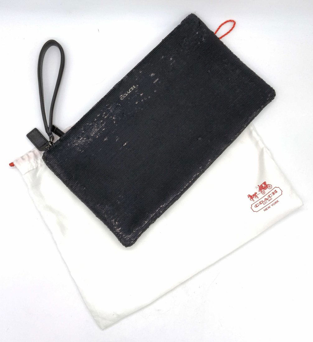 COACH Black Sequins Clutch W/ Dust Bag: A black hued sequins Coach clutch. Zipper closure. Interior lined with navy toned soft hand fabric. Exterior reads COACH in raised silver tone metal. Interior plaque reads Coach. Measures approx 7L x