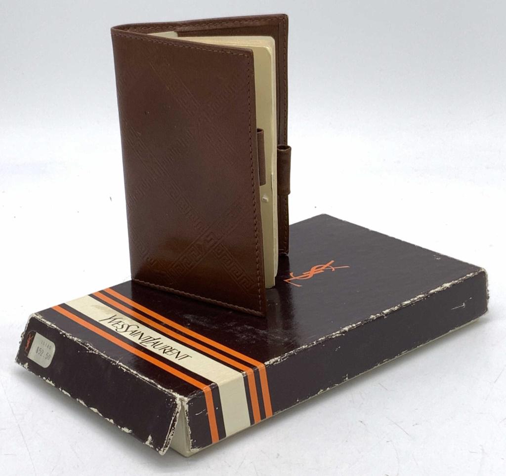 YVES SAINT LAURENT Vintage Pocket Phonebook: YVES SAINT LAURENT Vintage Pocket Phonebook, bound by brown leather with YSL insignia embossment, alphabetized & lined pages with gilt edges & lettering, book includes 2 pockets that can fit CC inside