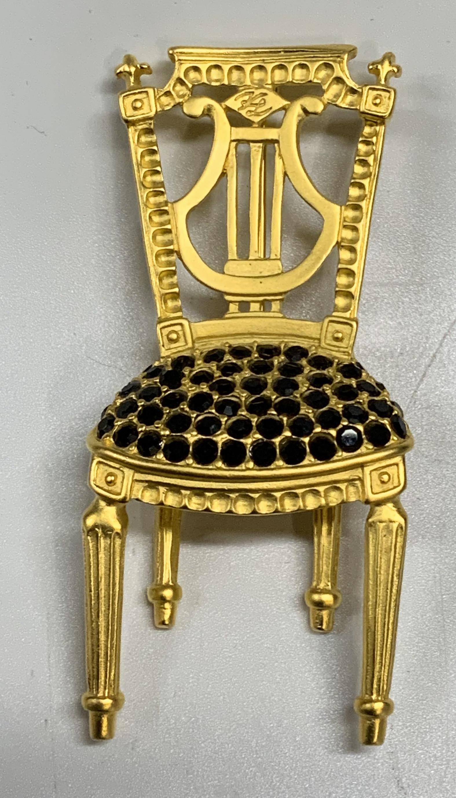 Vntg KARL LAGERFELD Lyre Chair Rhinestone Brooch: Vntg KARL LAGERFELD Lyre Chair Rhinestone Brooch, French chair with lyre back rest, Studded with clear rhinestones, Signed KL on top of the chair and on reverse., Matte gold tone finish. Measurements:
