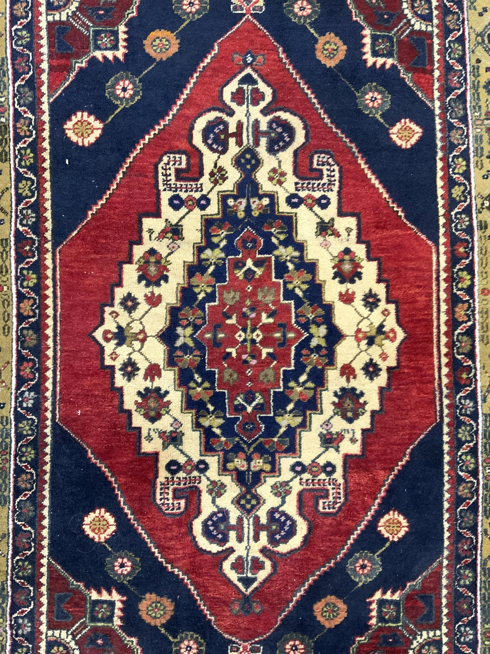 Vintage Handmade Turkish Fringed Wool Rug: Rug is handmade and wool. Piece is vintage possibly antique. Rug has intricate multi toned geometric, floral, vine, & leaf detail. Rug has short fringes at edges. Rug measures approx 77 inches long 46