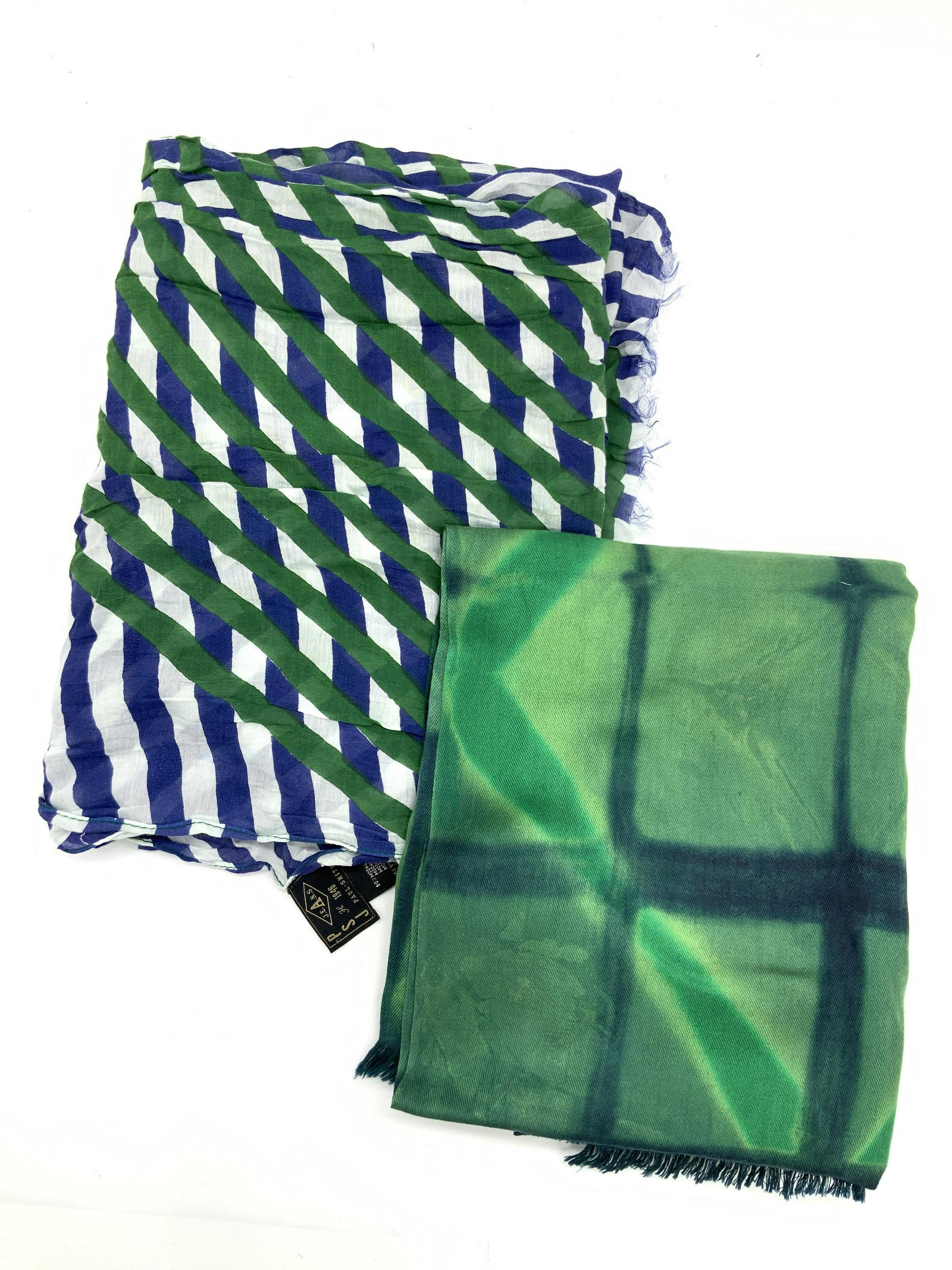 Blue & Green Scarves Paul Smith & More: A blue and green and white scarf with intersecting lines creating multiple patterns,marked on tag Paul Smith, 50% Modal 60% viscose. And a green toned scarf with square like patterns resembling tie dy