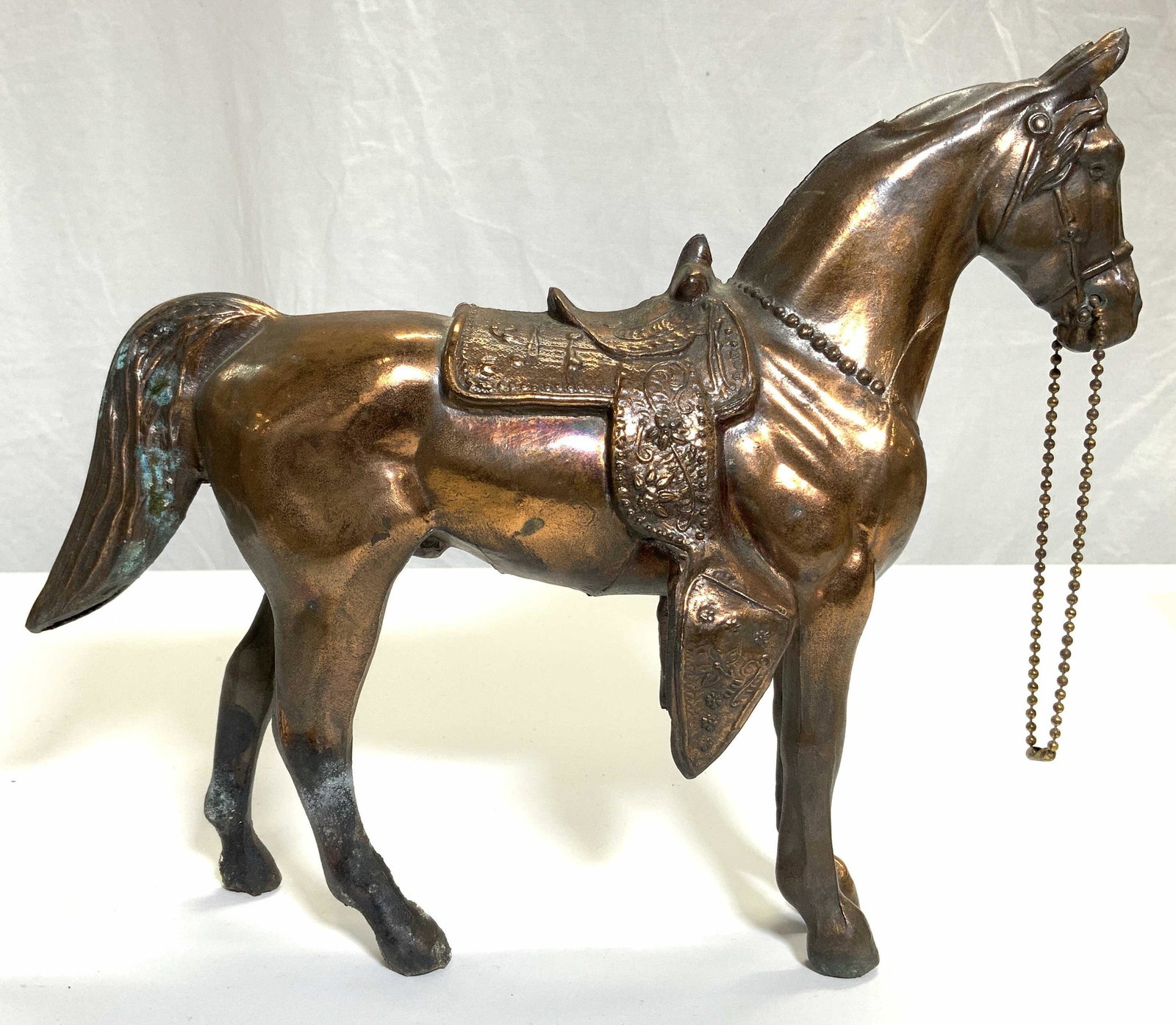 Vntg Copper Horse Figure W Relief Detail: Horse figure appears to be copper. Piece has intricate facial, saddle & tail fur relief detail. Figure has beaded structure attached to mouth area. Piece measures approx 13 inches long 10.5 inches tal