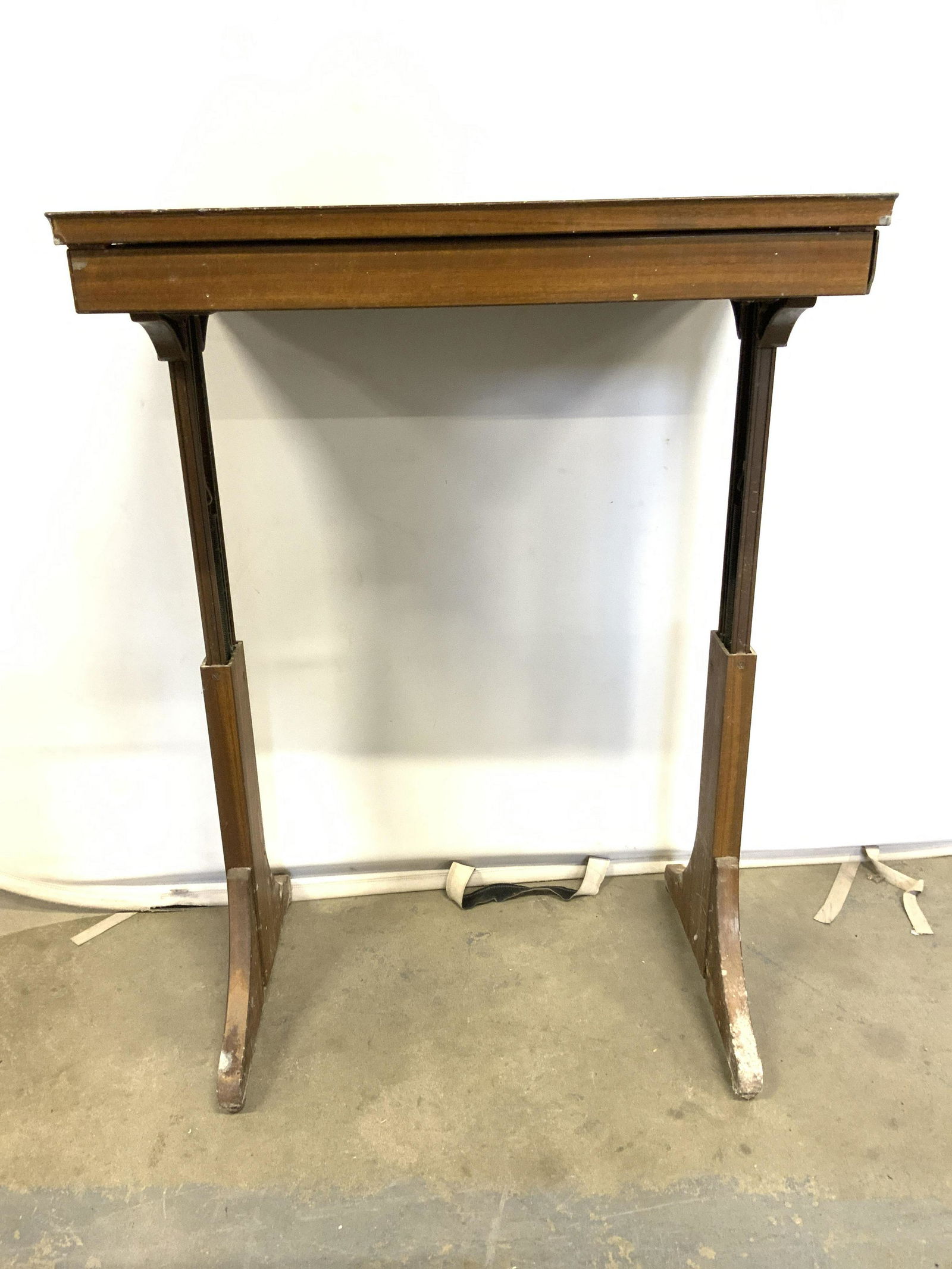 Antique Wooden Adjustable Writers Desk: Desk is antique and wooden. Lid flips open. Piece has cranberry toned top which appears to possibly be leather. Desk has 2 supports each appear to have height adjustment mechanism. Piece has current h