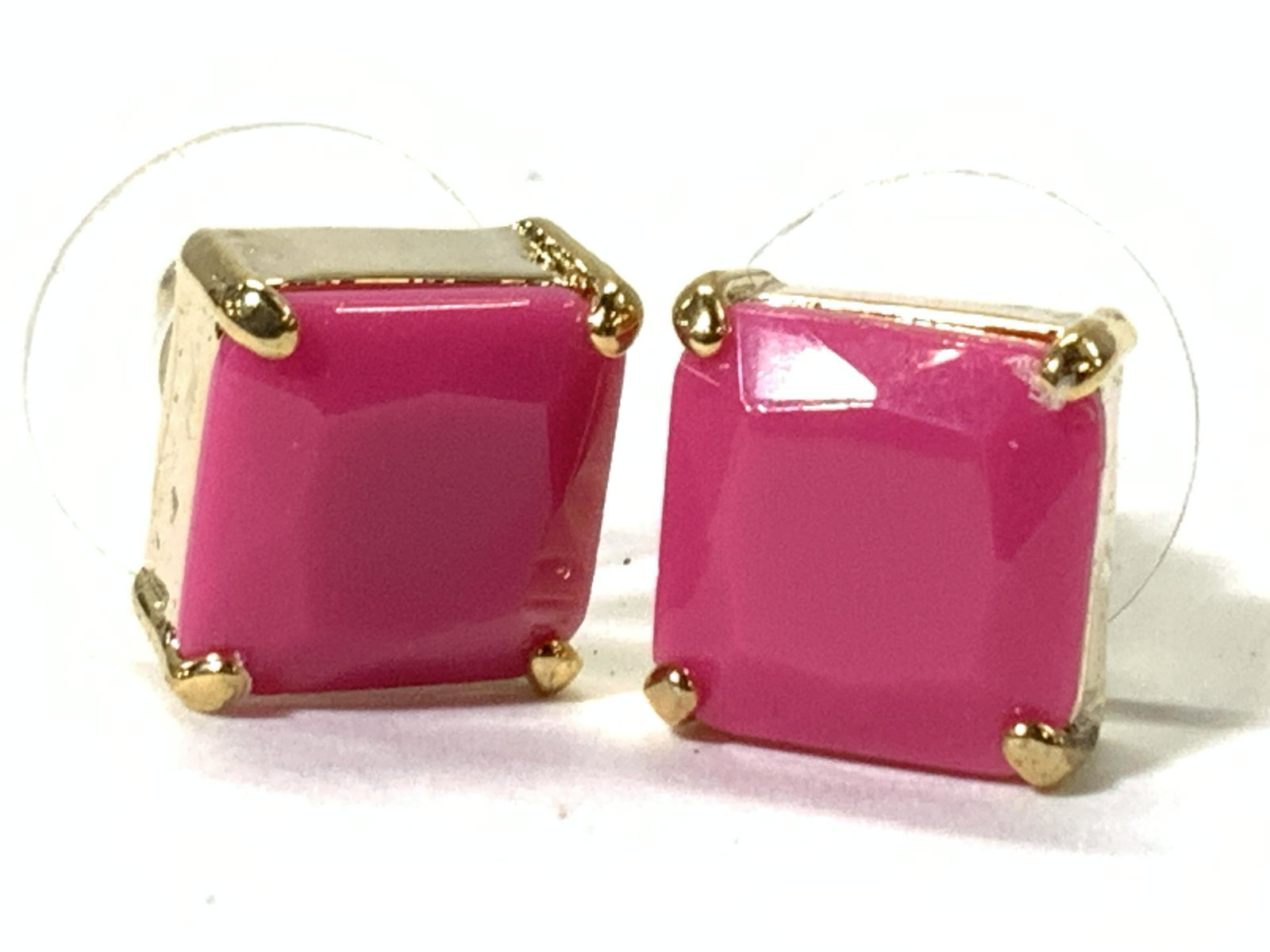 CAROLEE Gold Toned Costume Stud Earrings: Pair of stud earrings with rubber backings, with gold toned metal prong setting of matte pink square cut glass stone. Approximately 0.25 inches wide. Comes in original store display card marked Carole