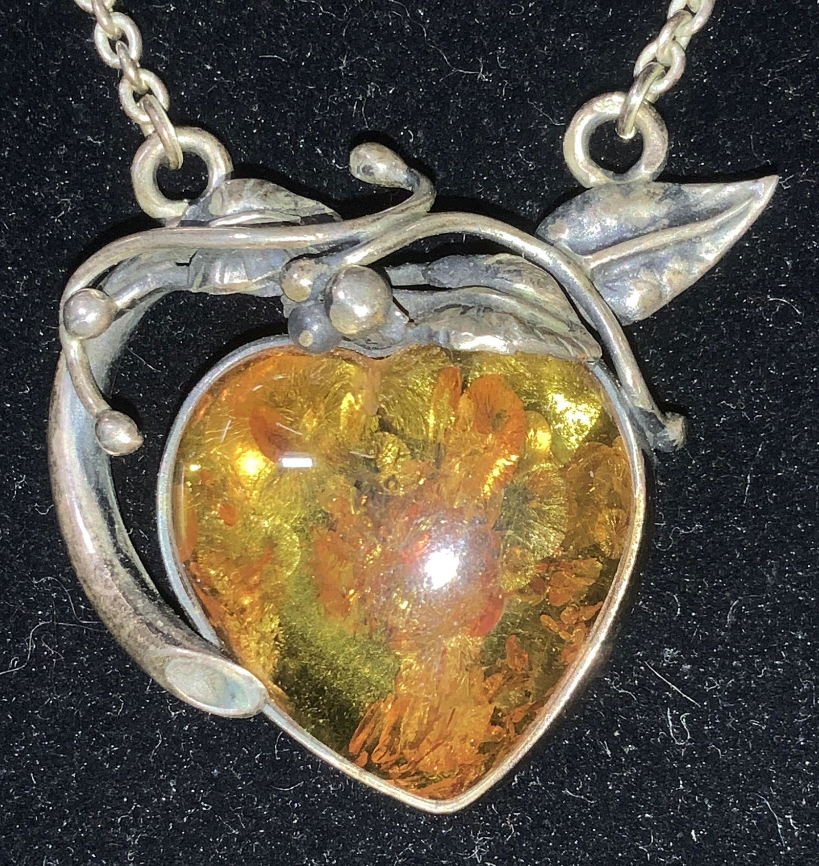 Sterling Art Nouveau Amber Style Pendant Necklace: Candle chain, clasp marked 925, 14 in. With resin amber heart pendant set in sterling with scroll and leaf art nouveau decor. Pendant metal tests positive for fine silver, not marked. Pendant measures