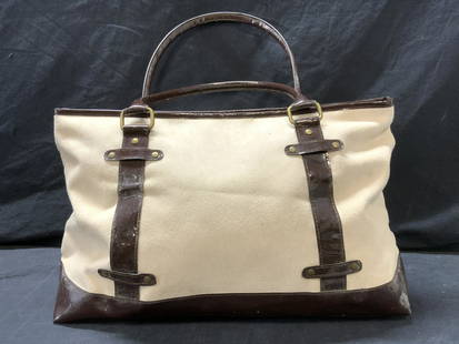 ESTEE LAUDER Tote Bag: ESTEE LAUDER Tote Bag, cream colored suede like-material and brown toned pleather detail exterior with brown polyester interior, zipper closure, bronze toned hardware. Measures approx 11 in. L x 17 in