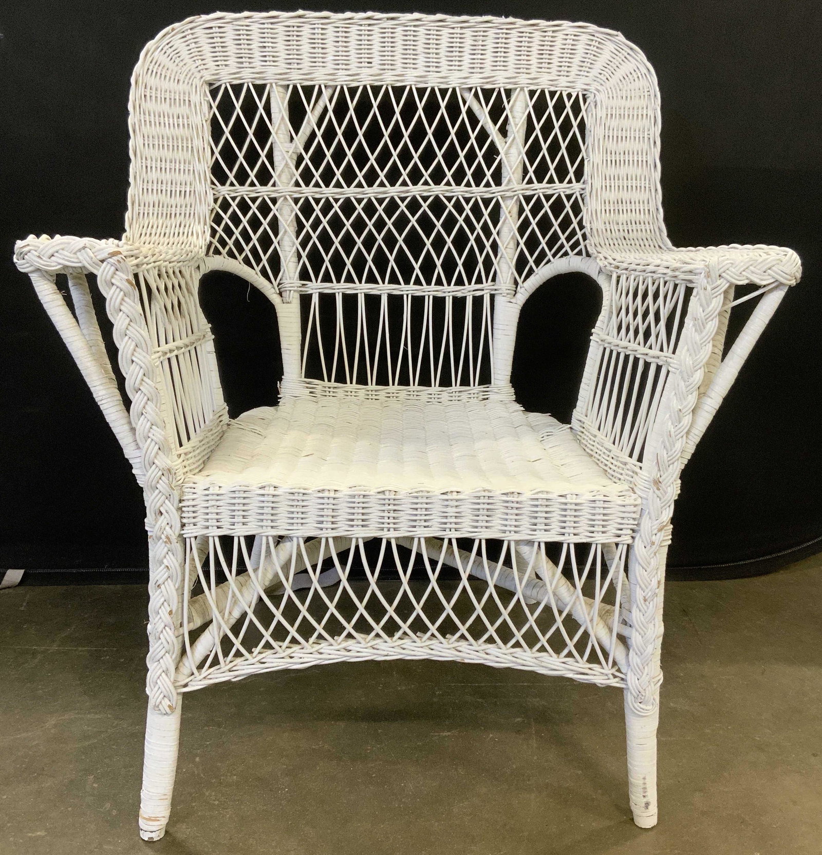 Hand Painted Woven Wicker Chair: Hand painted wicker arm chair. Woven wicker arm chair. Surface wear and chipping to paint present. Measures approx 36 inches h, 30 inches w, 24 inches deep. Home decor, decorative accessories, decorat