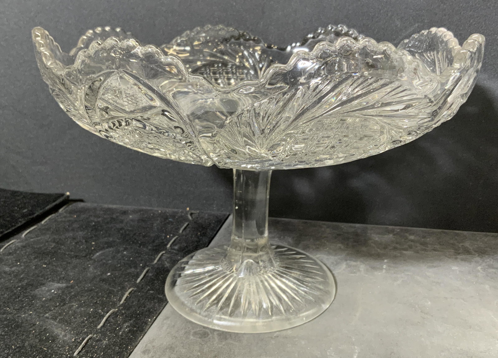 Cut Glass Pedestal Bowl: Cut glass pedestal bowl. Various cut glass designs, toothed edge. Measures approx 7 inches h and 10.5 inches w. Home decor, pedestal bowl, tazza, dessert bowl, tabletop decor, tabletop accessories. 9