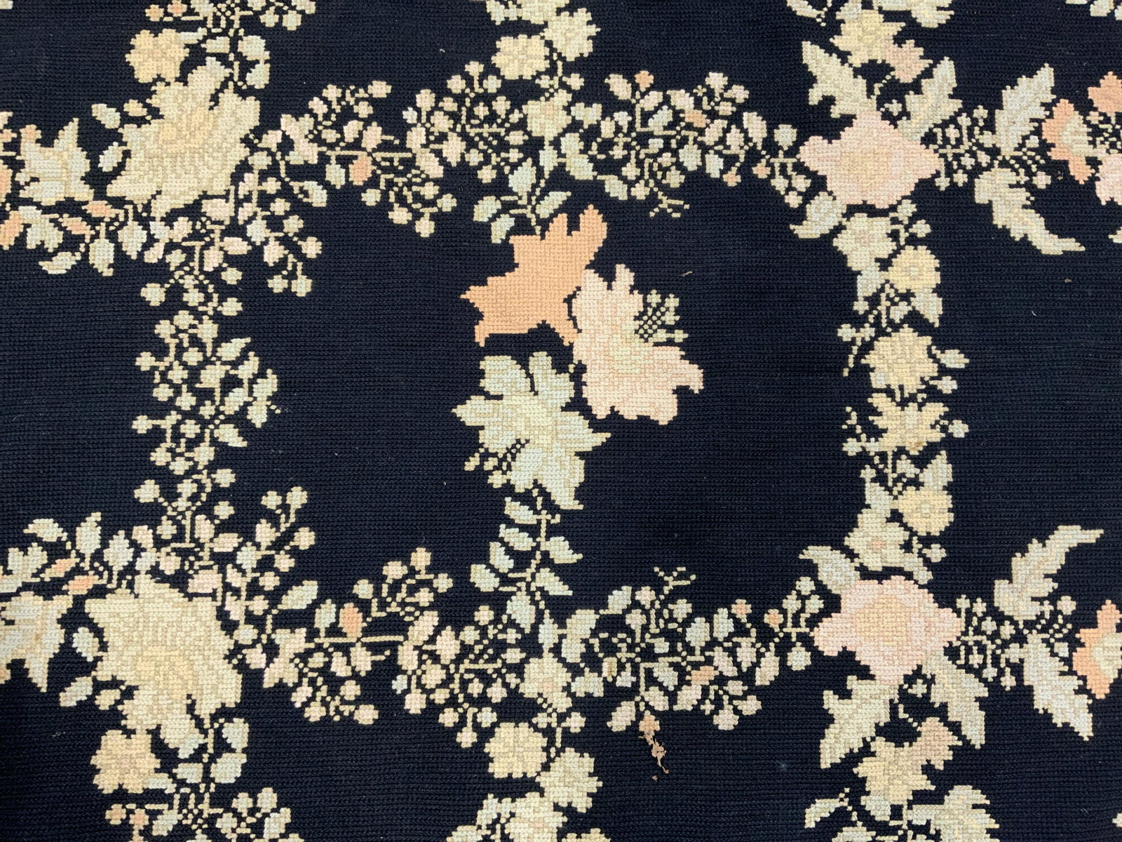 Vintage Area Rug: Vintage area rug. Decorated with multi toned floral patterns. Black base. Possibly hand made. Tearing and surface wear present. Measures approx 108 inches long, 72 inches w. Home decor, decorative acc