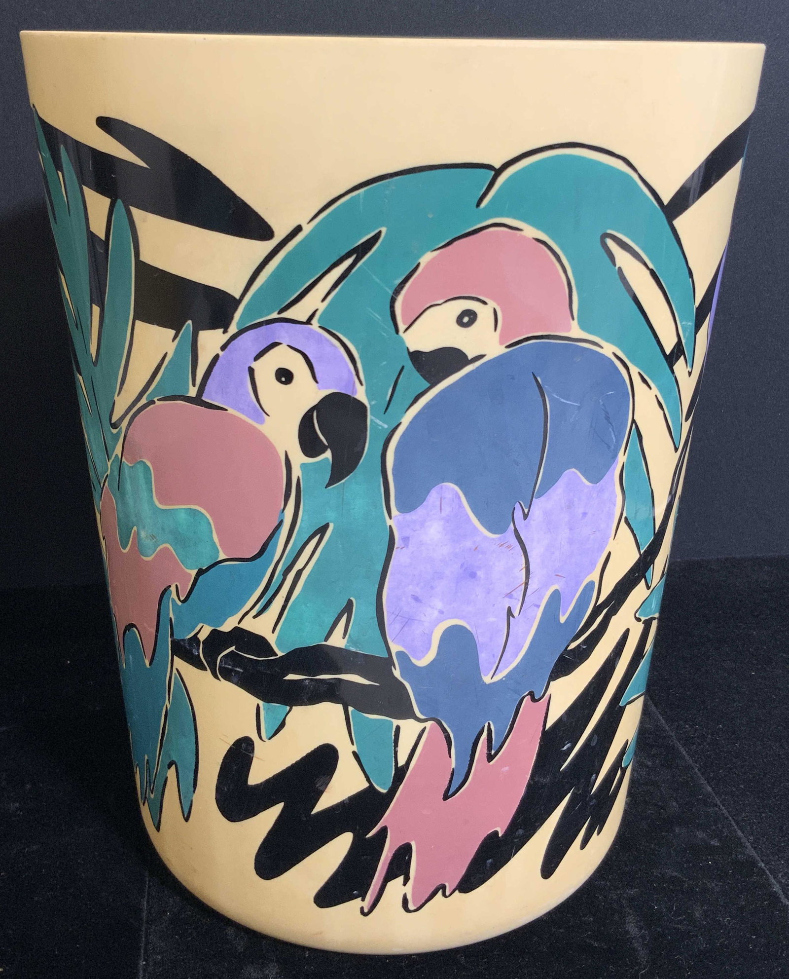 Vintage Composite Parrot Motif Bin: A vintage composite bin decorated with a colorful, tropical parrot motif. Cylindrical form. Measures 10H x 8W in. Surface wear and some discoloration. Vintage bin, Receptacle, garbage can, vessel, par
