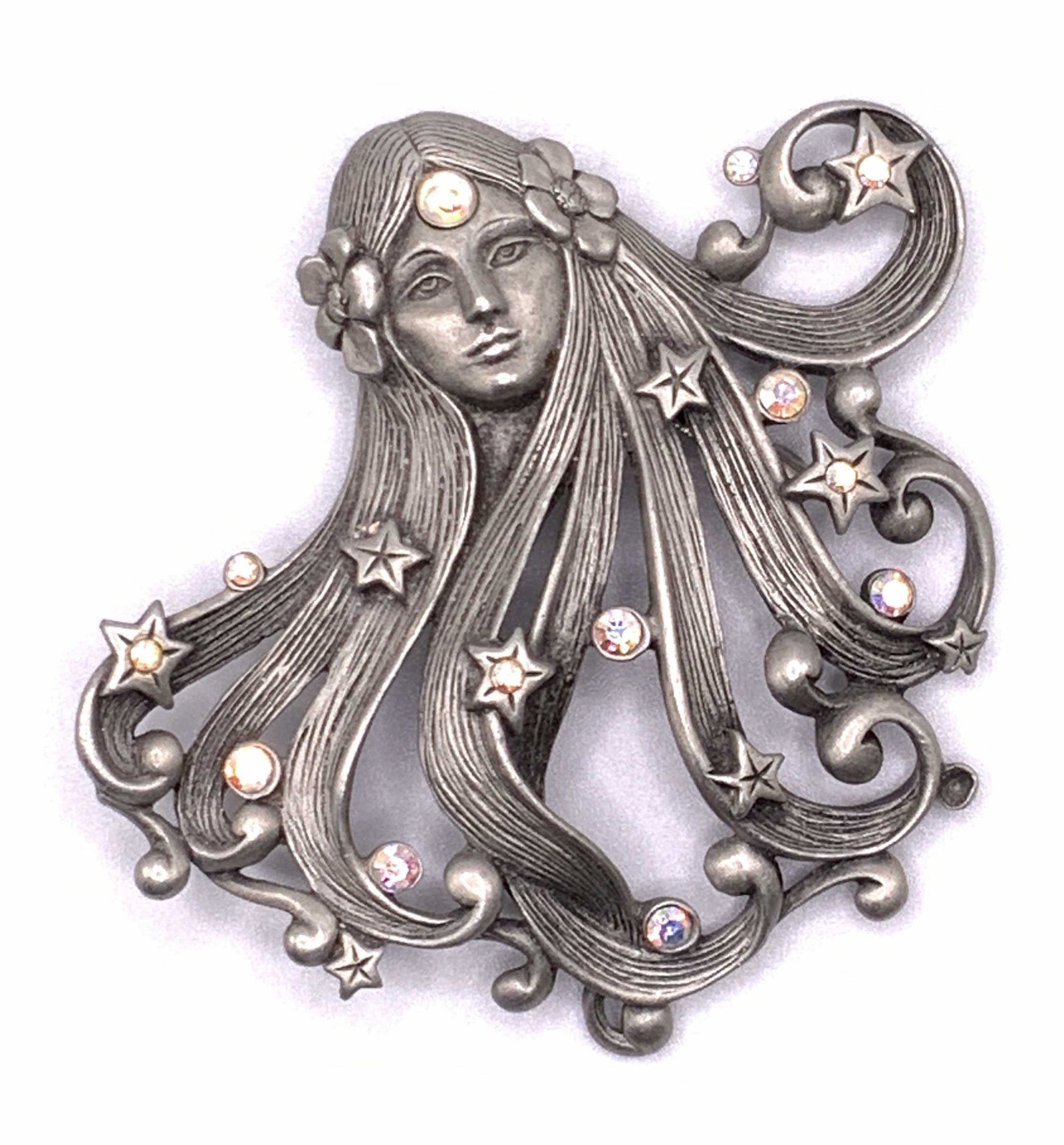 JJ Signed Vintage Art Nouveau Female Crystal Pin: A vintage silver tone etched metal pin / brooch depicting an art nouveau style females face. Her long wavy hair is studded with faceted Aurora Borealis crystals. Flowers on either side of her head. Un