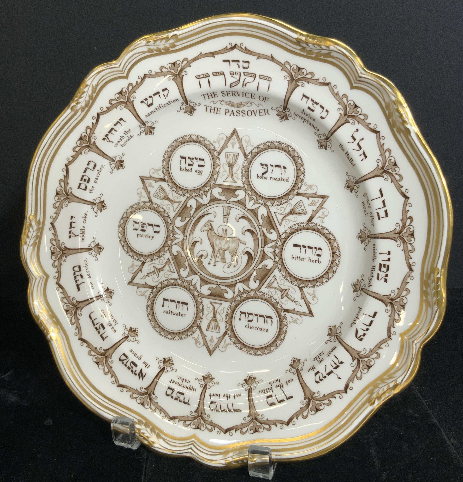 SPODE Bone China Service of Passover Plate, ENG: A bone china plate decorated with gilt line work, a scalloped rim, and Hebrew & English writing. Center design depicts a goat. Top of piece reads THE SERVICE OF THE PASSOVER. Underside signed SPODE BO